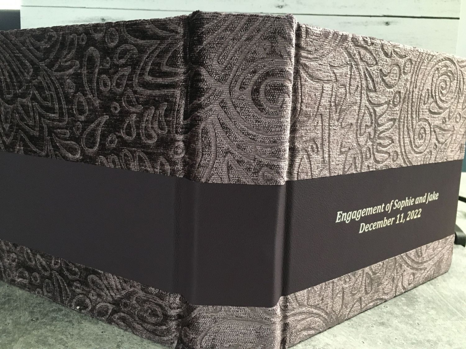 Side view of a purple velvet engagement album, showcasing its rich texture and elegant design.