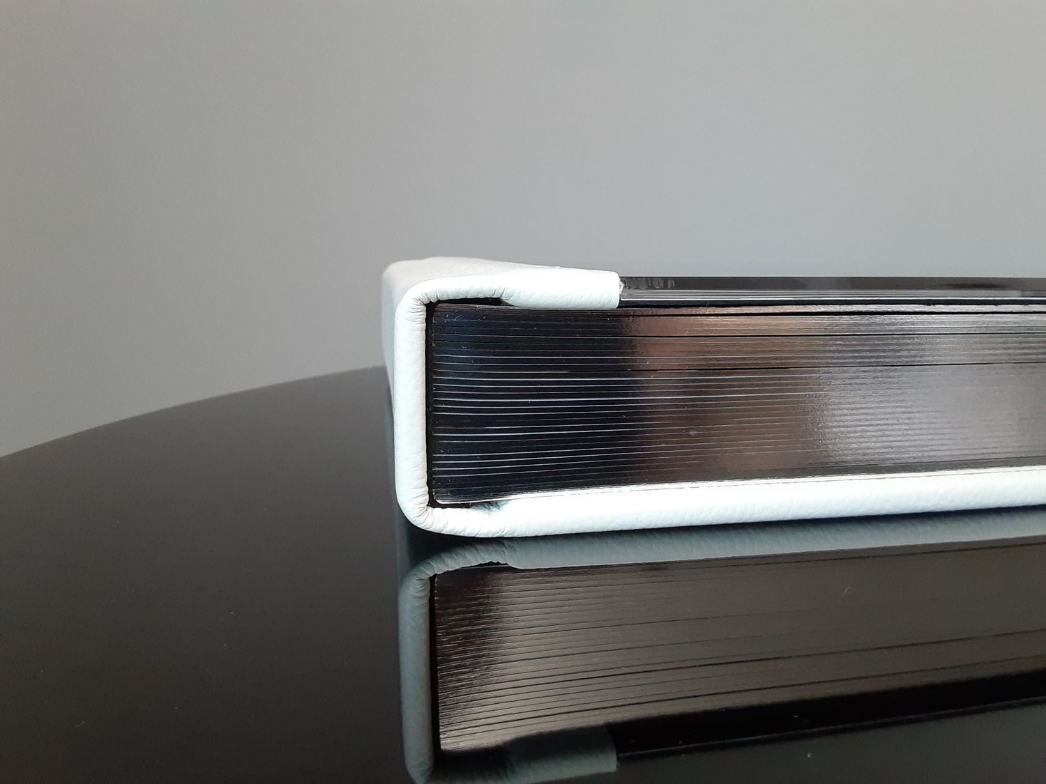 Acrylic photo album displayed on a black surface, highlighting its sleek and modern design.