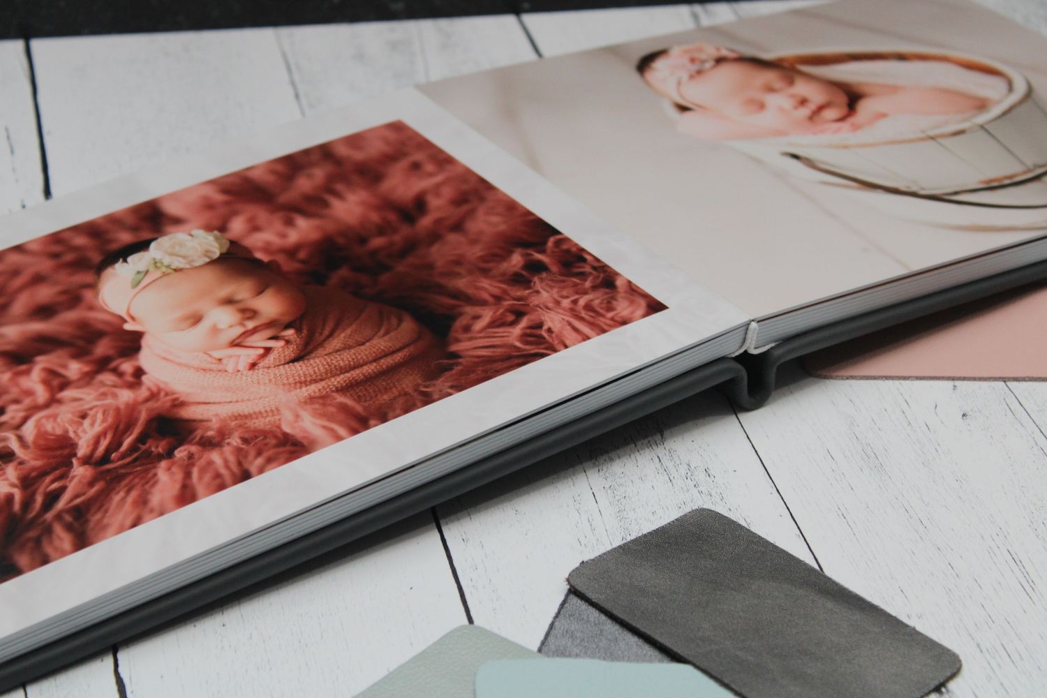 Baby album displayed on white wooden surface with colors watches in the background
