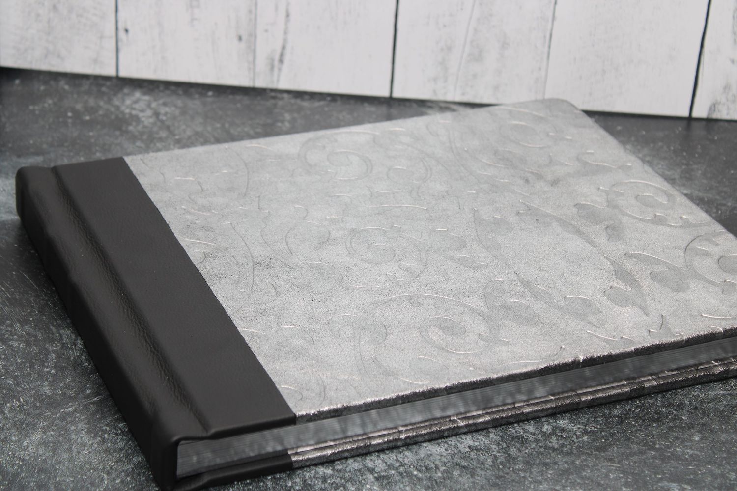 Silver cover leather photo album with black leather binding, combining elegant design and timeless style.