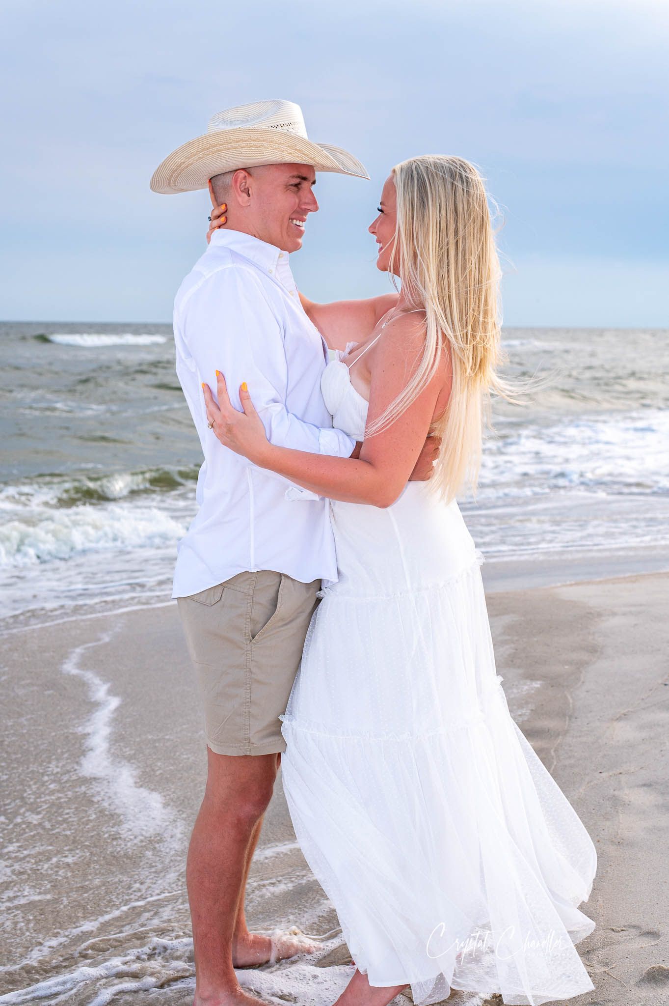 Photograhy, photographer, Mobile, AL  A romantic beach photoshoot with couple in white attire standing in ocean waves at sunset.