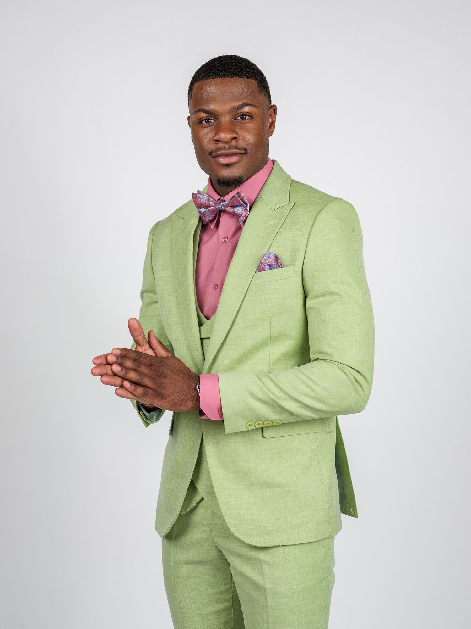 A professional portrait of a dapper mint green suit paired with pink accessories.