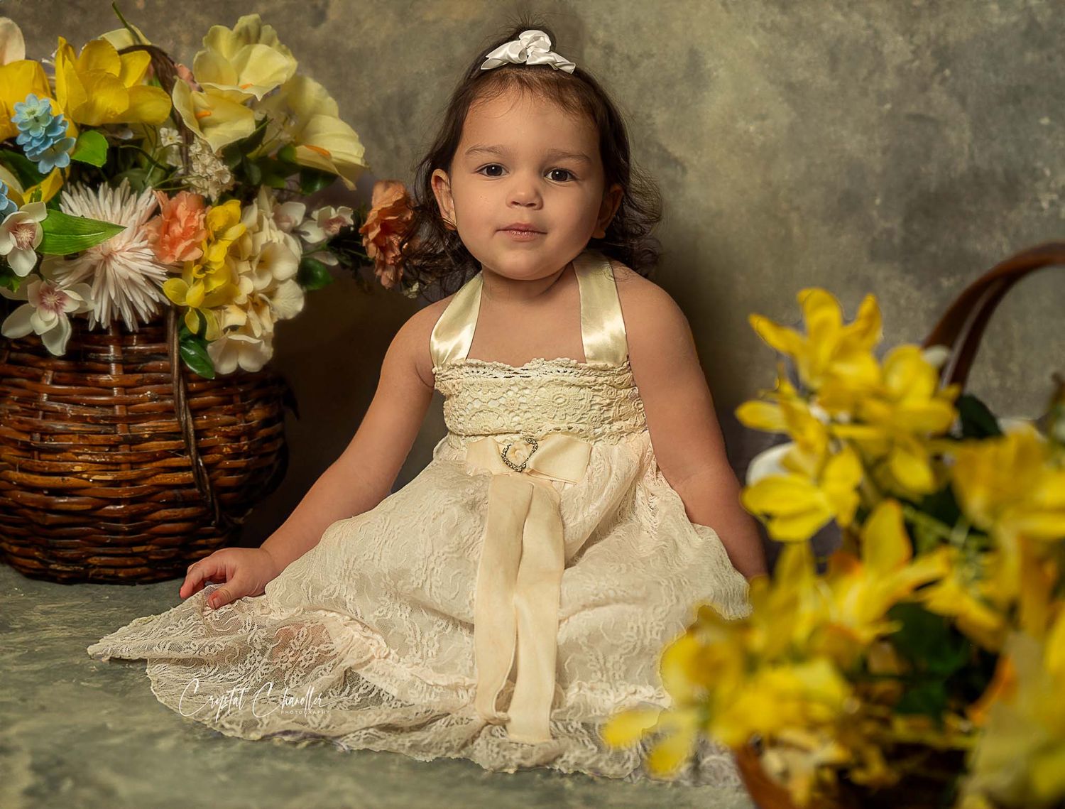 Photograhy, photographer, Mobile, AL A little girl in a cream lace dress poses with yellow daffodils and a wicker basket.