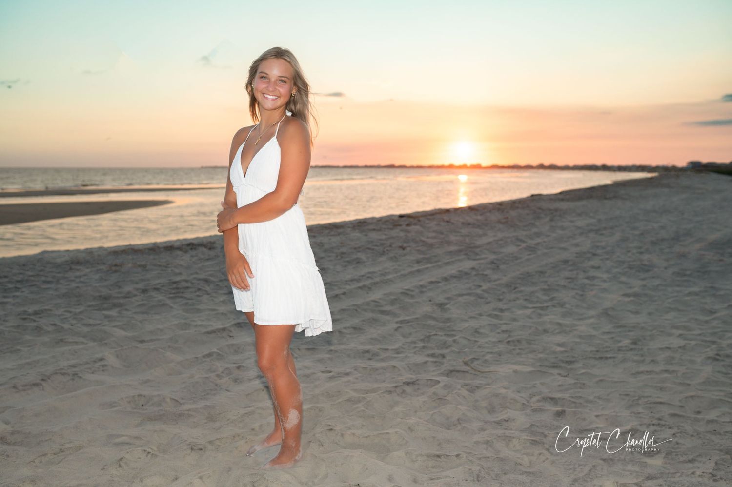 Photograhy, photographer, Mobile, AL  Woman in white dress poses on beach at sunset casting long shadows in the sand.