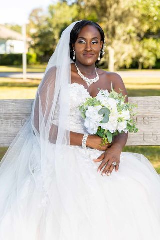 Bridal portrait outdoors with white flowers and elegant veil.