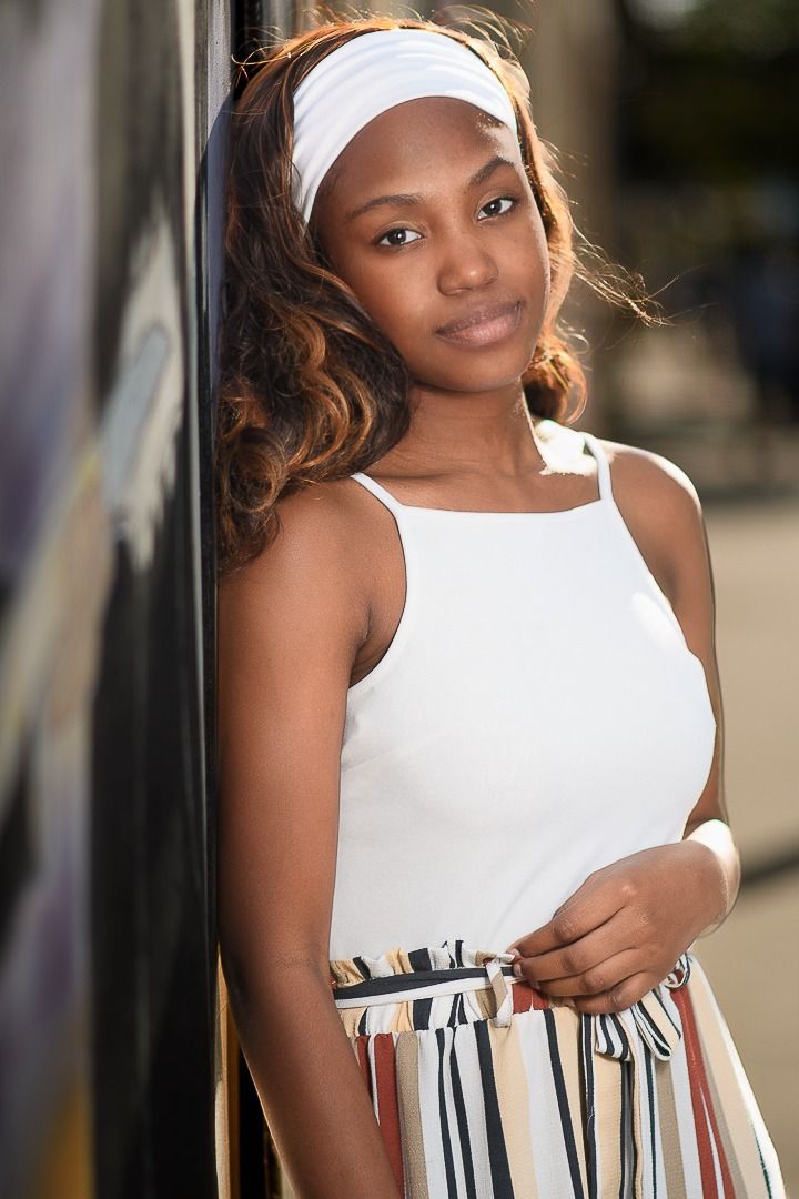 Summer portrait in white tank top and striped skirt with matching headband.
