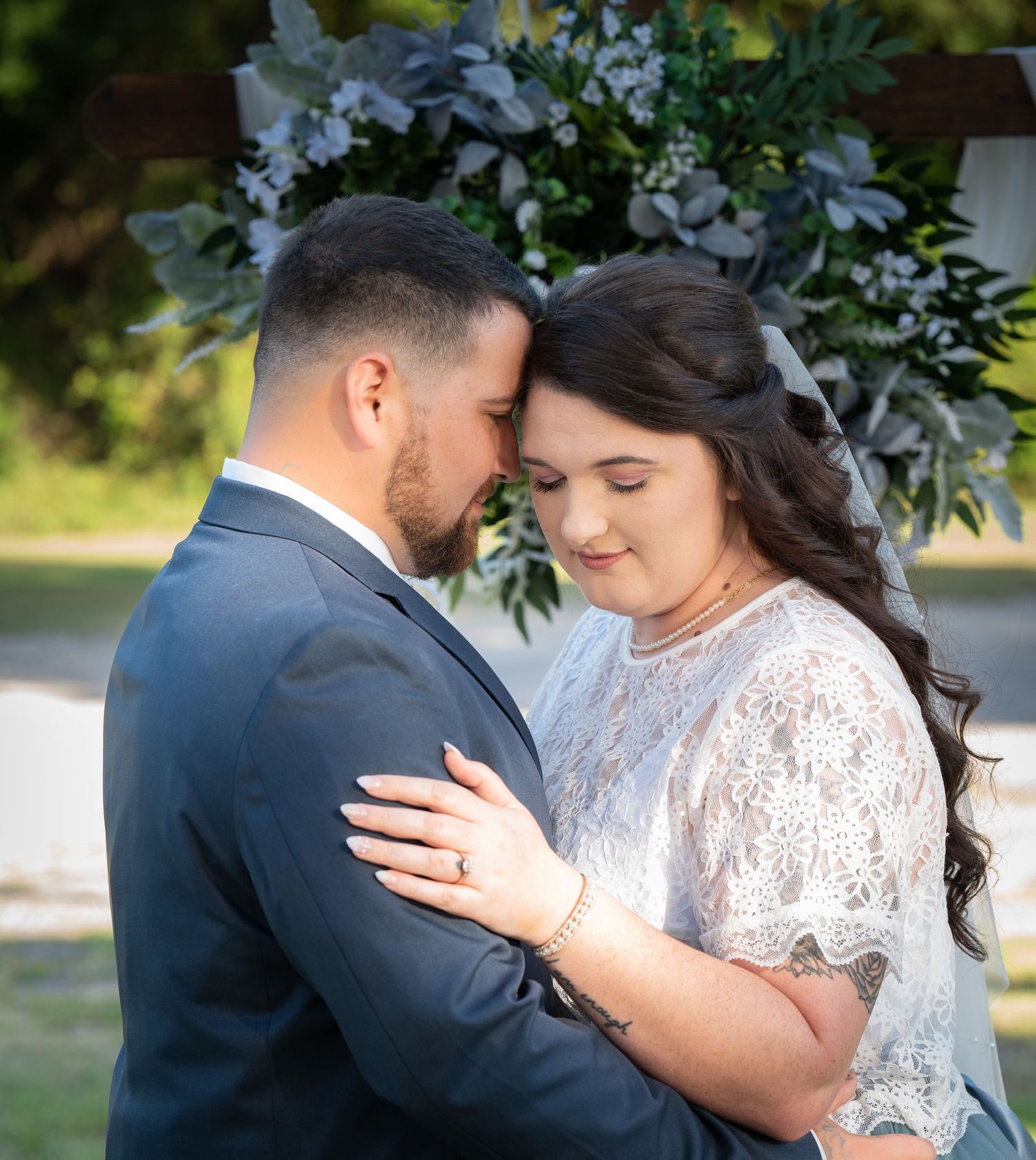 A romantic moment captured in a series of wedding photos showing a couple embracing in an outdoor garden setting.