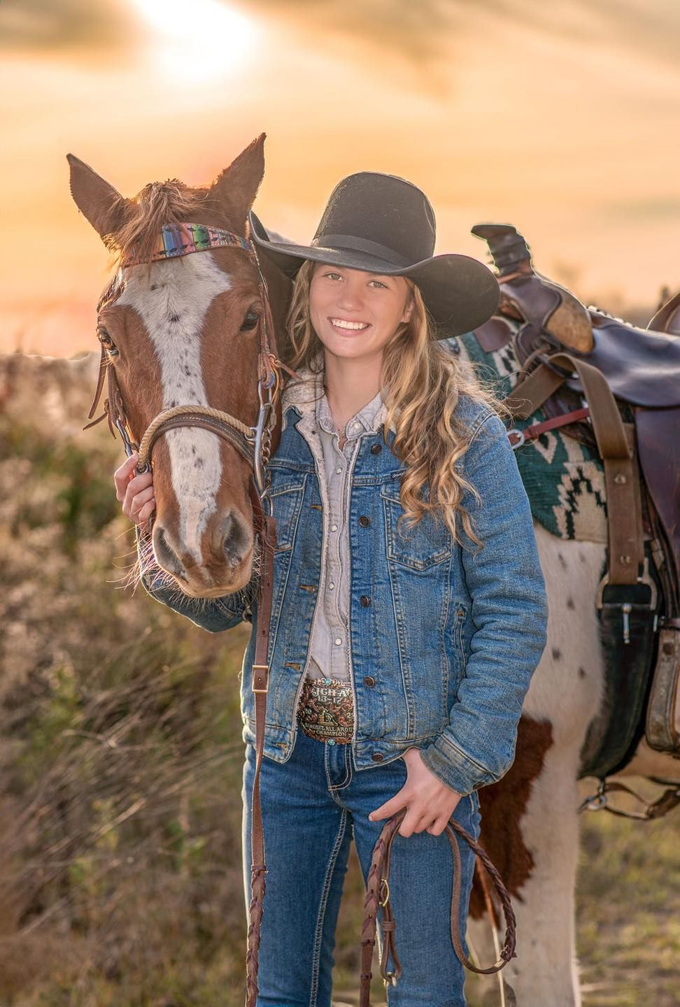 Photograhy, photographer, Mobile, AL  Cowgirl in denim jacket poses with brown and white horse during golden sunset.