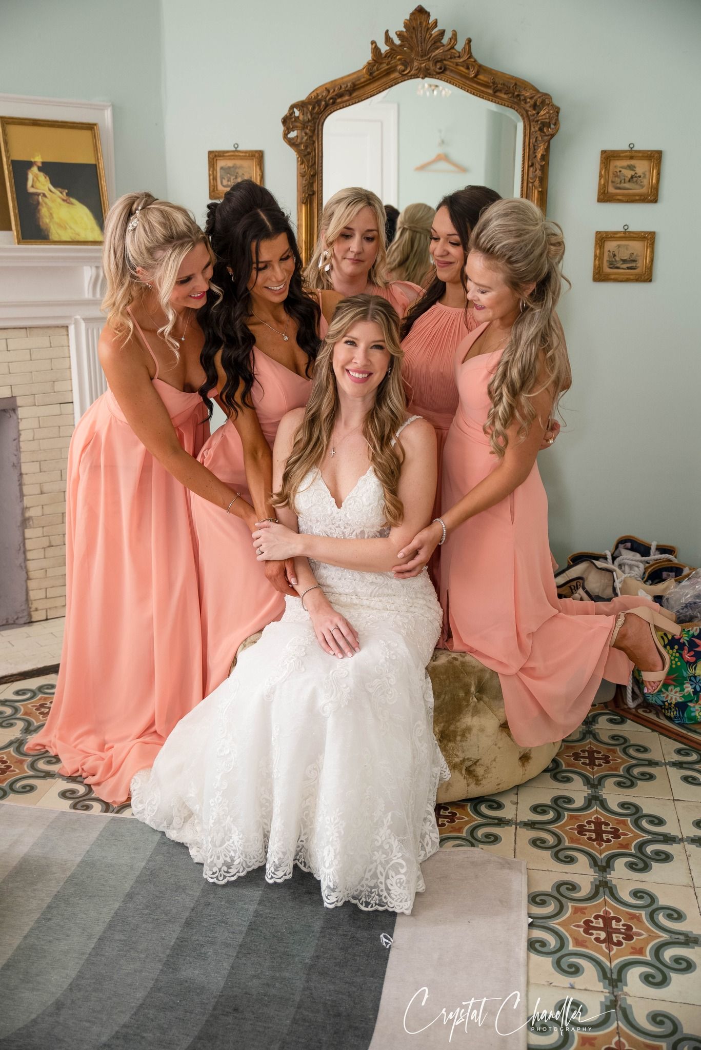 Photograhy, photographer, Mobile, AL  Wedding party in peach dresses gather around seated bride in elegant room with ornate mirror.