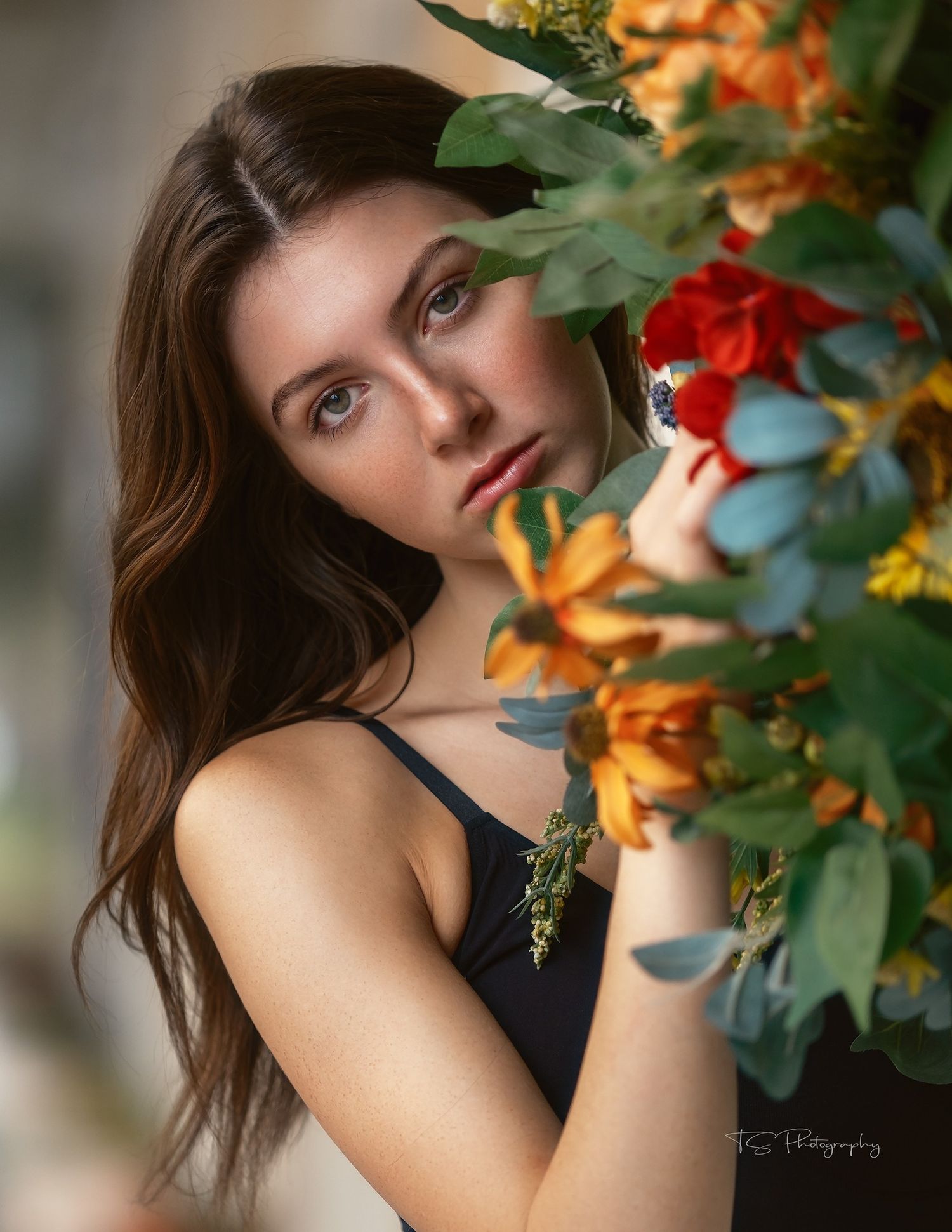 Portrait with orange and red flowers framing the subject in artistic style.