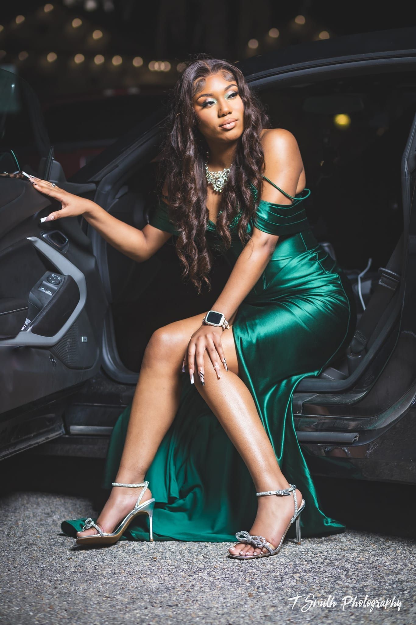 Glamorous evening photo in emerald green gown posed elegantly by car door.