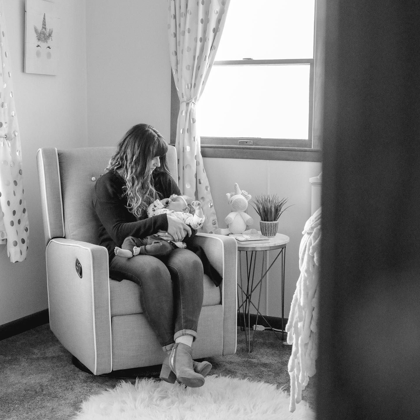 Nurturing moment in a cozy nursery corner with rocking chair and soft window light.