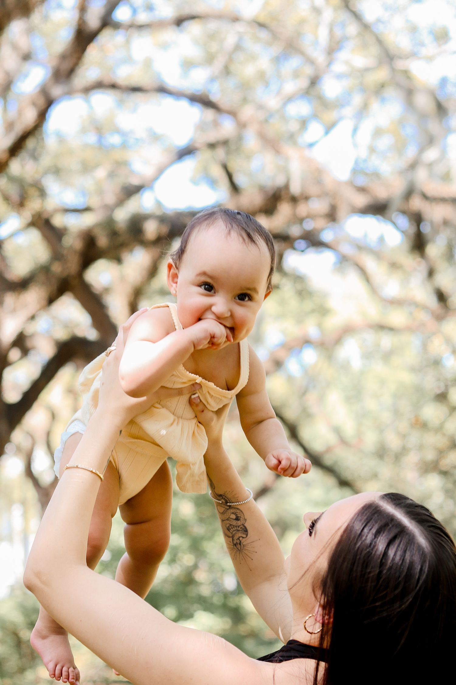 Playful moments captured under blooming spring trees during outdoor photo session.