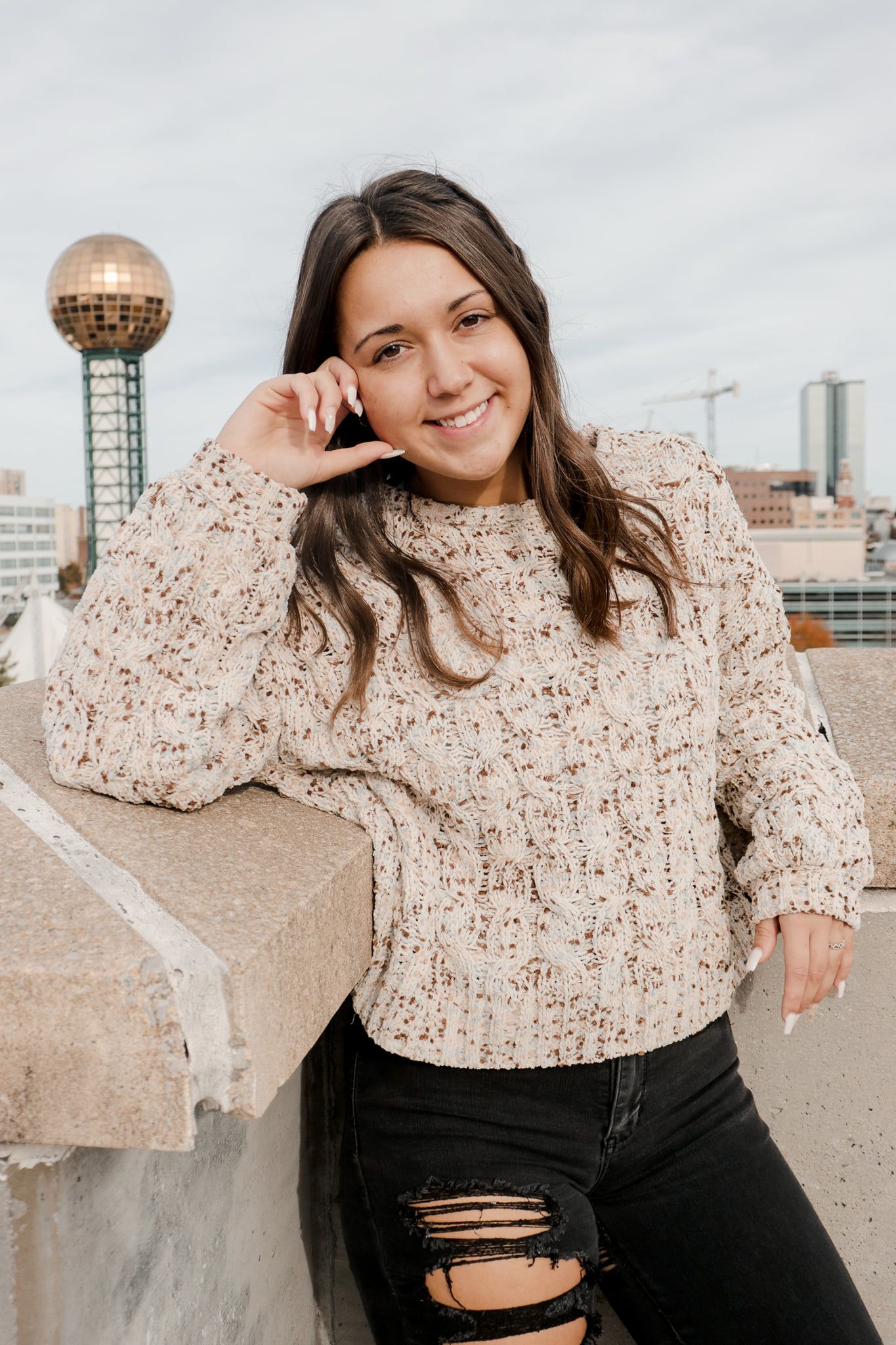 Casual rooftop portrait with Knoxville skyline and Sunsphere in background.