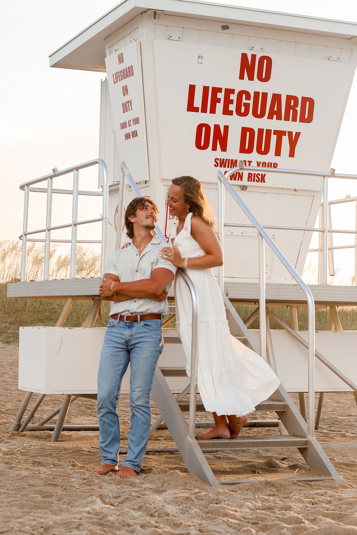 A couple shares a romantic moment by a lifeguard stand with 