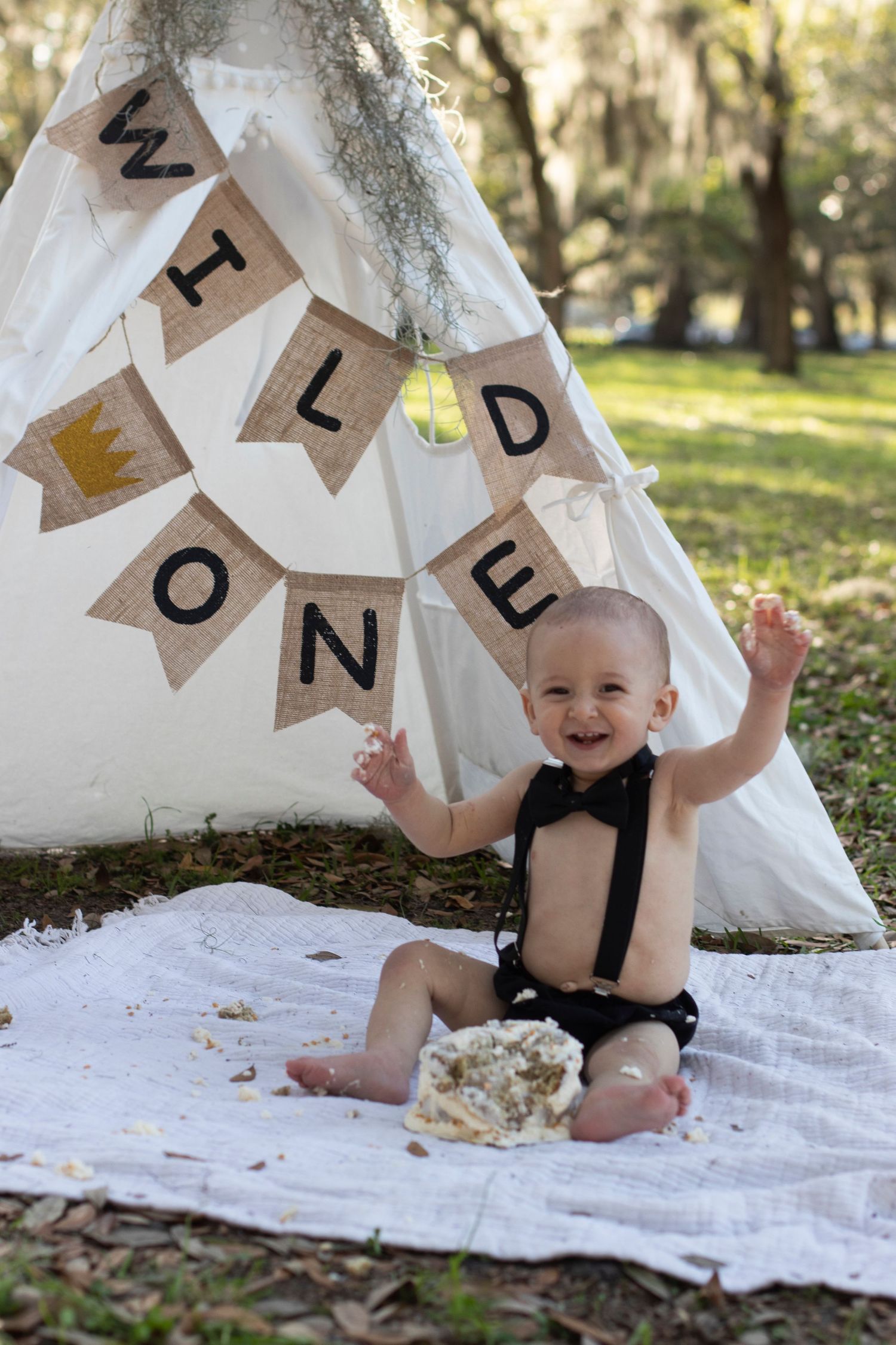 Birthday celebration with rustic bunting banner and white teepee tent setup.