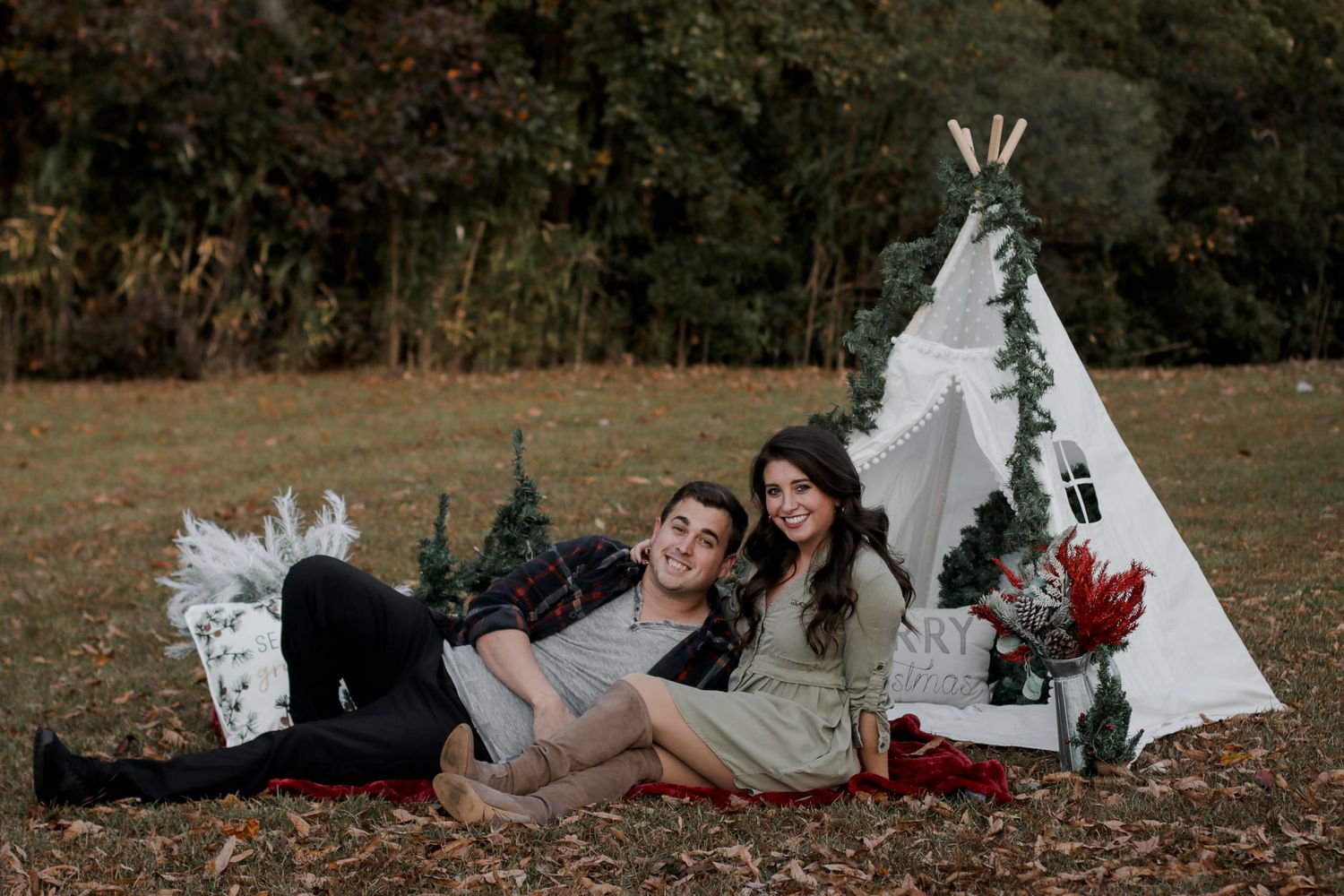 Relaxed outdoor photography setup with teepee and fallen autumn leaves.