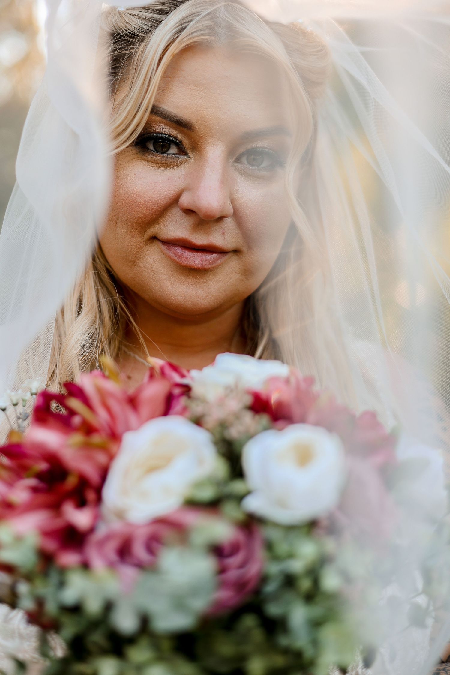 Bridal portrait with pink and white bouquet in natural sunlight.