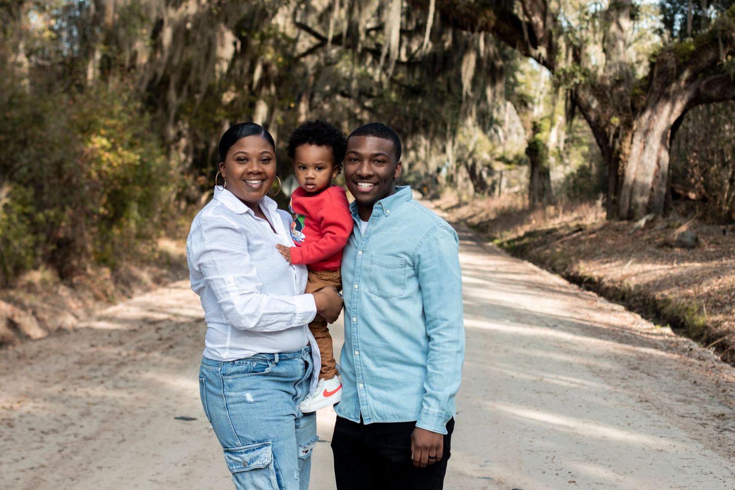 Casual outdoor family portraits on a tree-lined path.
