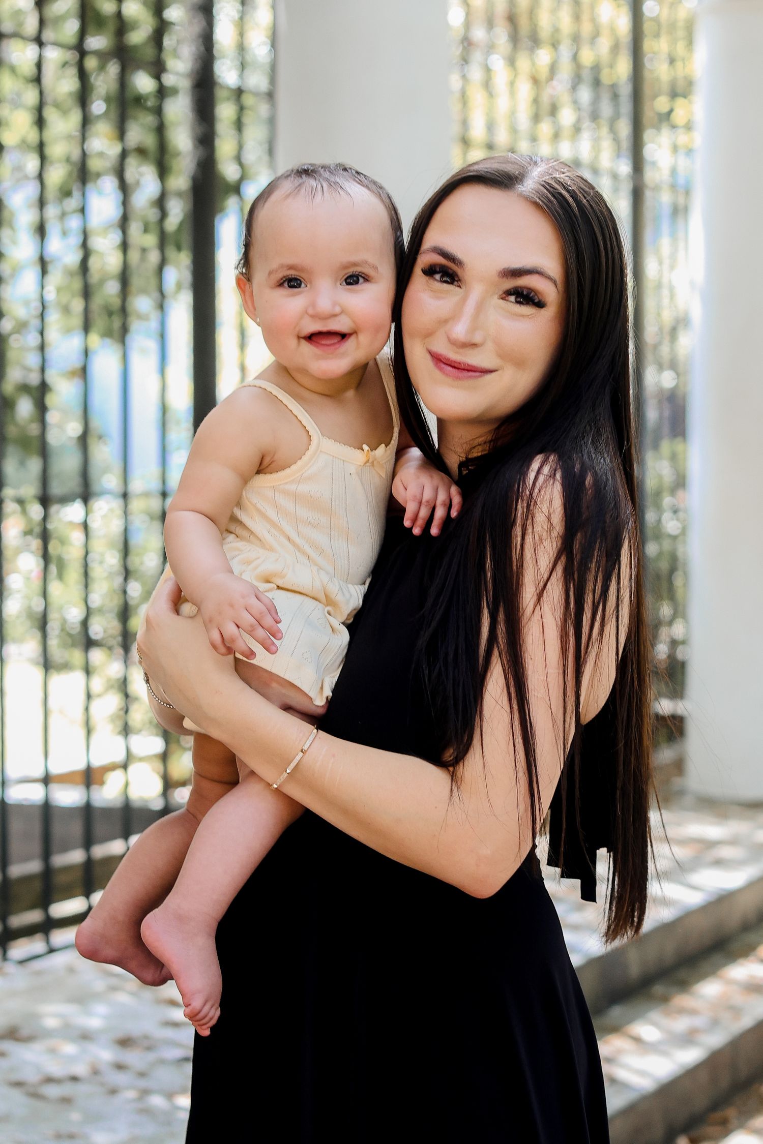 Joyful indoor portraits captured in natural light with white columns and trees in background.