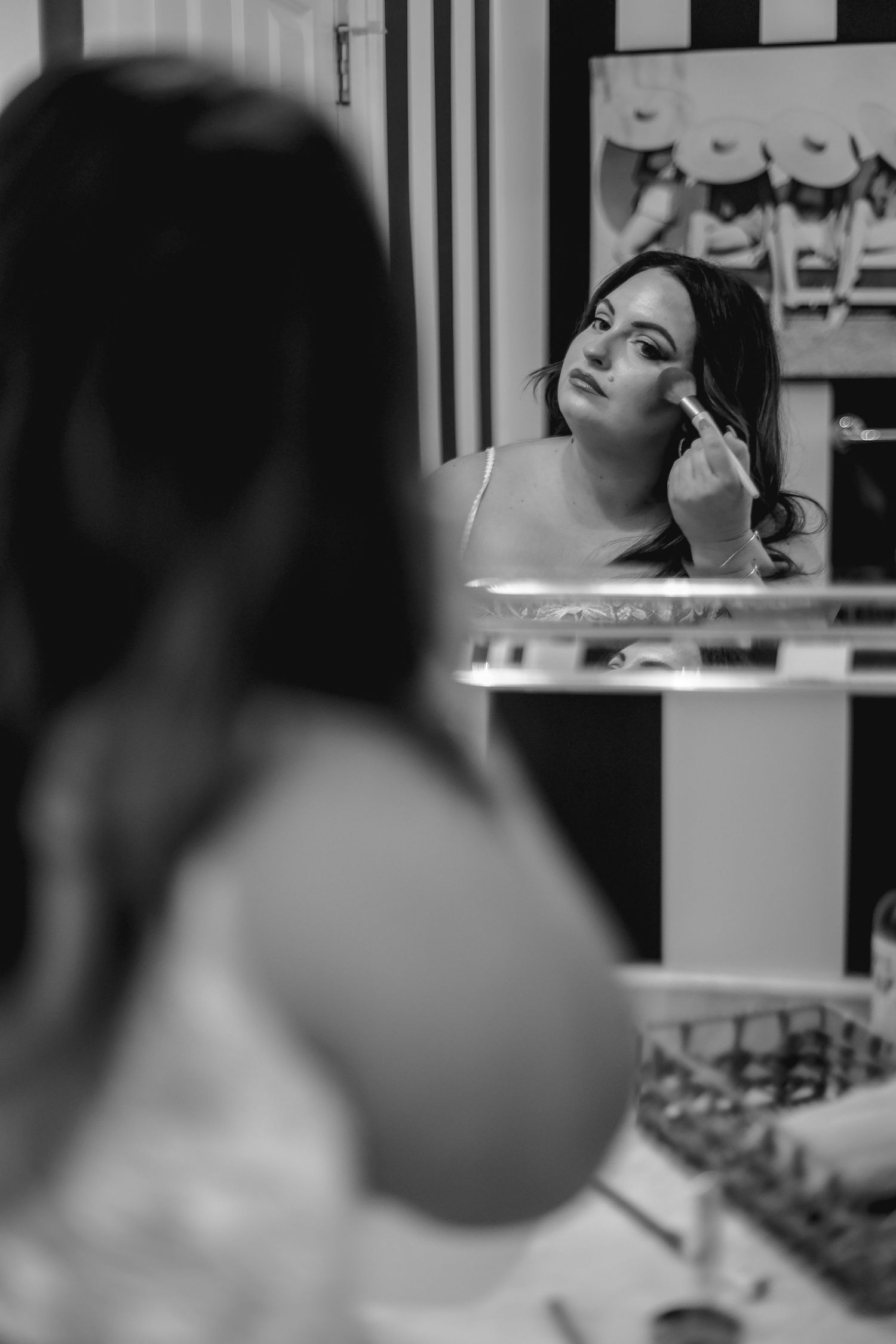 Black and white candid shots of wedding preparations in a makeup room.