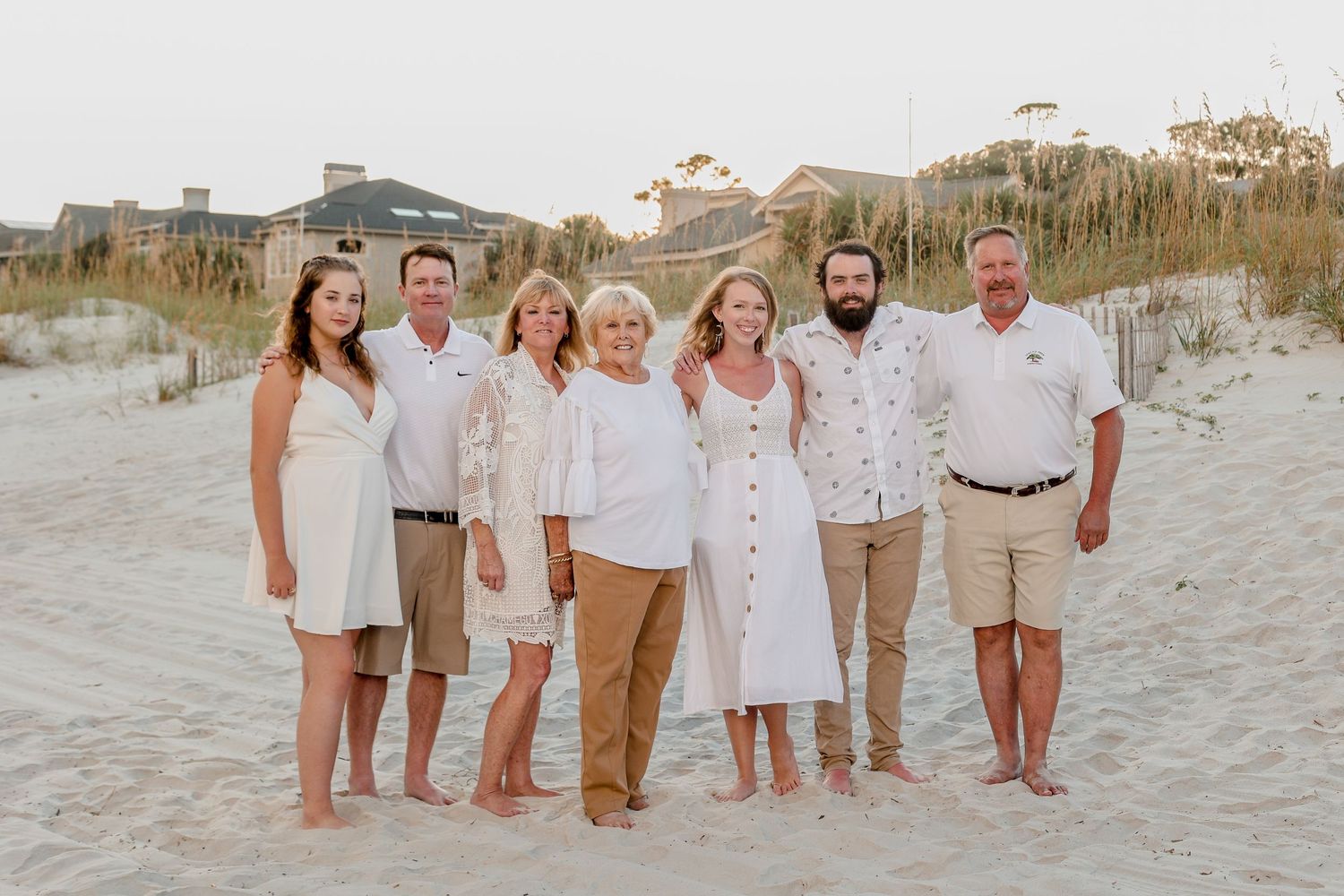 Extended family portrait session on beach wearing coordinated neutral colors.