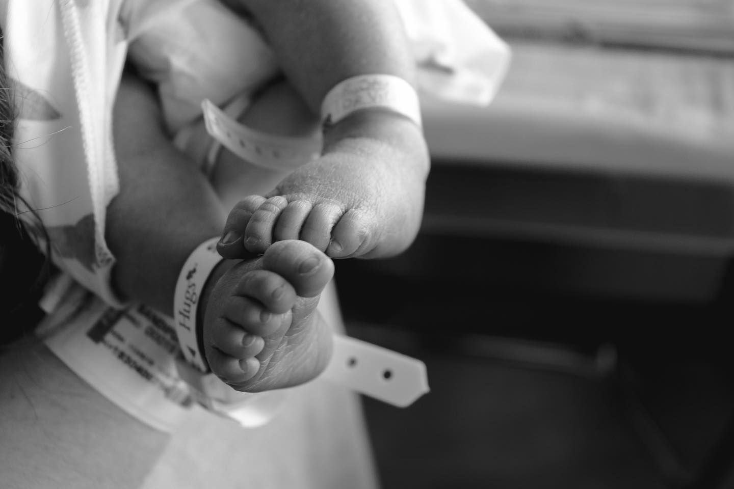 Close up of tiny newborn baby feet in black and white.