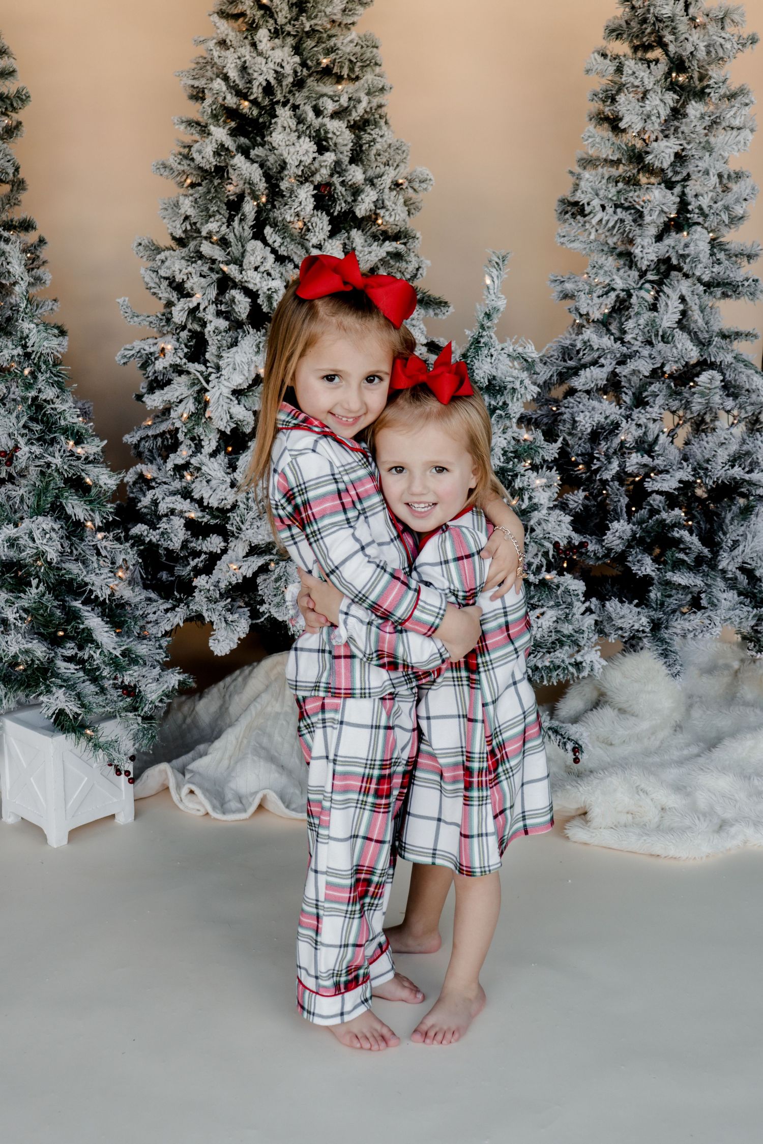 A winter scene with frosted Christmas trees and festive matching plaid pajamas.