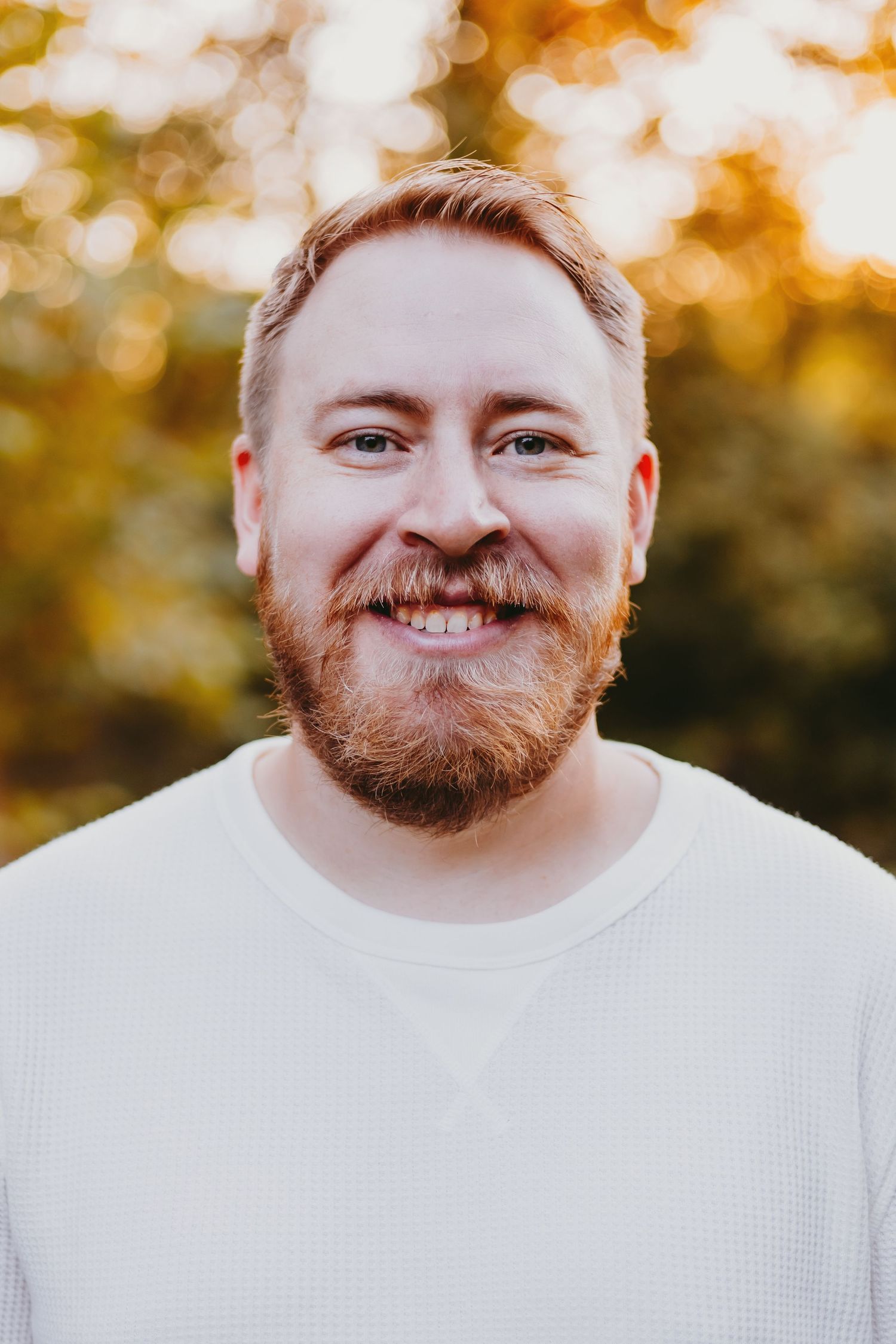 A sequence of three close-up portraits showing a smiling person with a ginger beard wearing a white shirt against a blurred background.