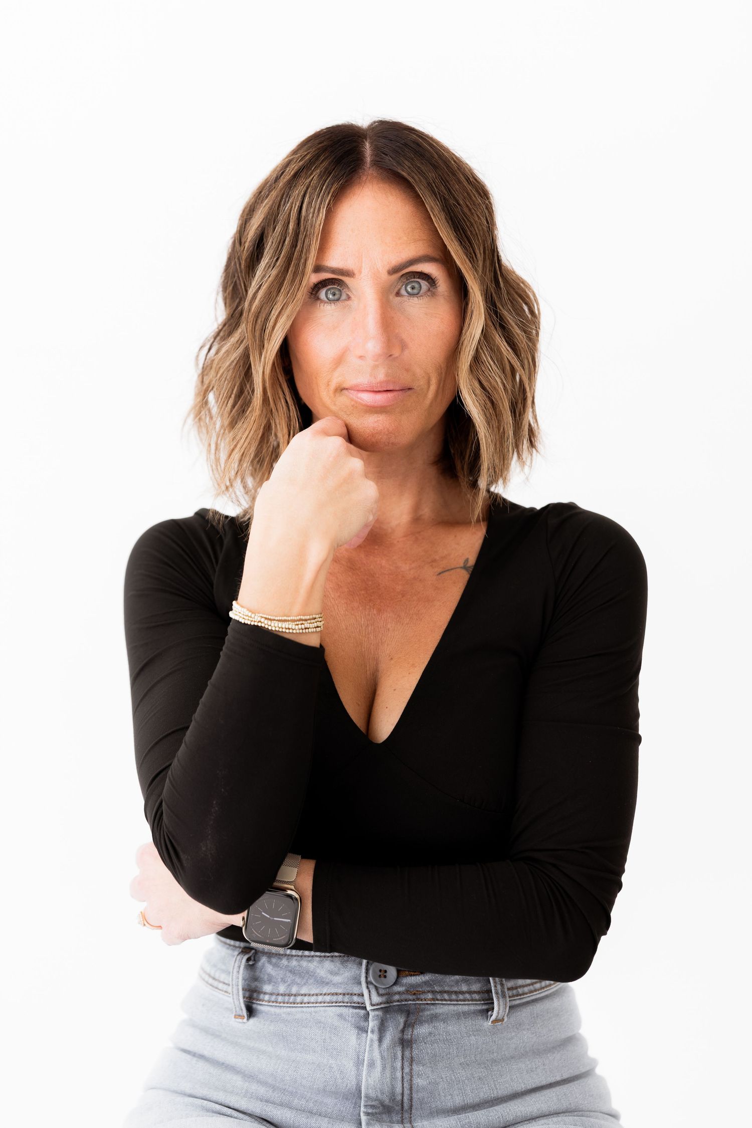 Four lifestyle portraits showing a casual pose in black top and jeans against white background.