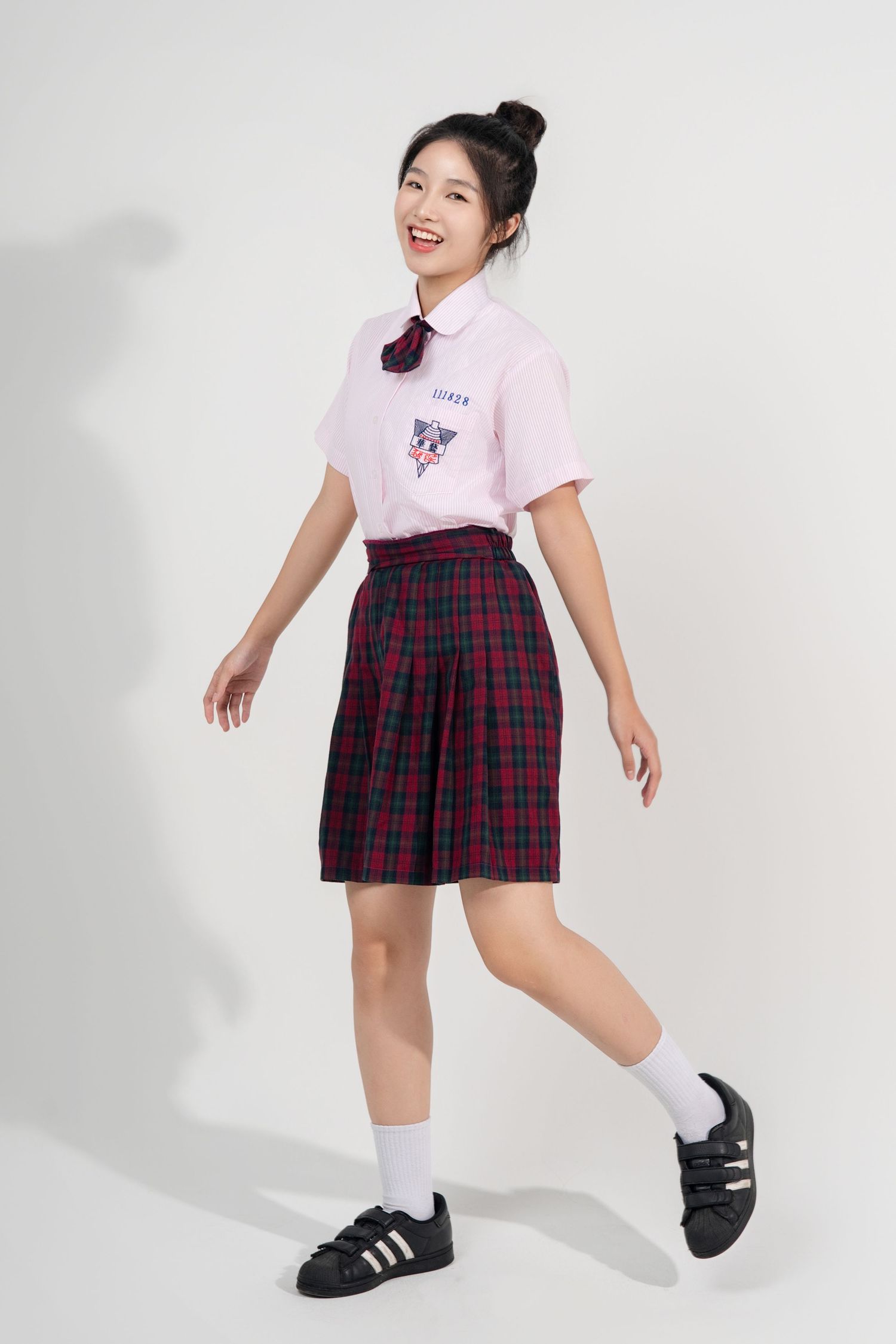 A student wearing a pink top and plaid skirt strikes playful poses in a series of studio shots against a white background.