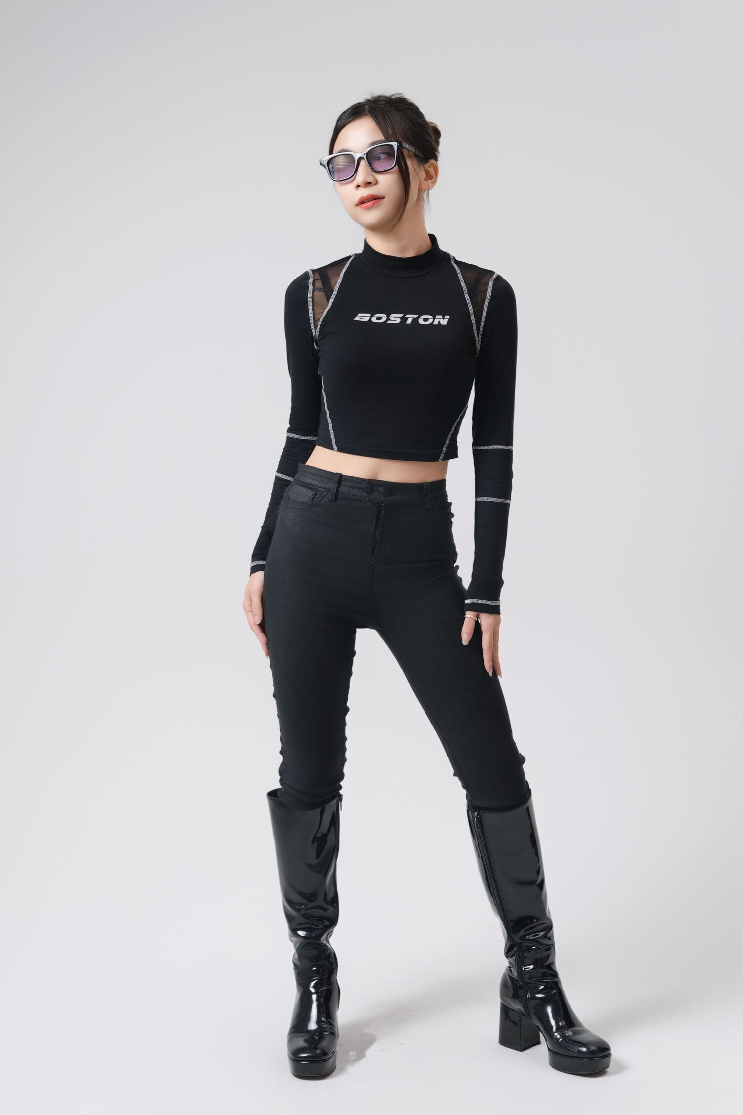 Person in black crop top and pants strikes fashionable poses against white background wearing platform boots.