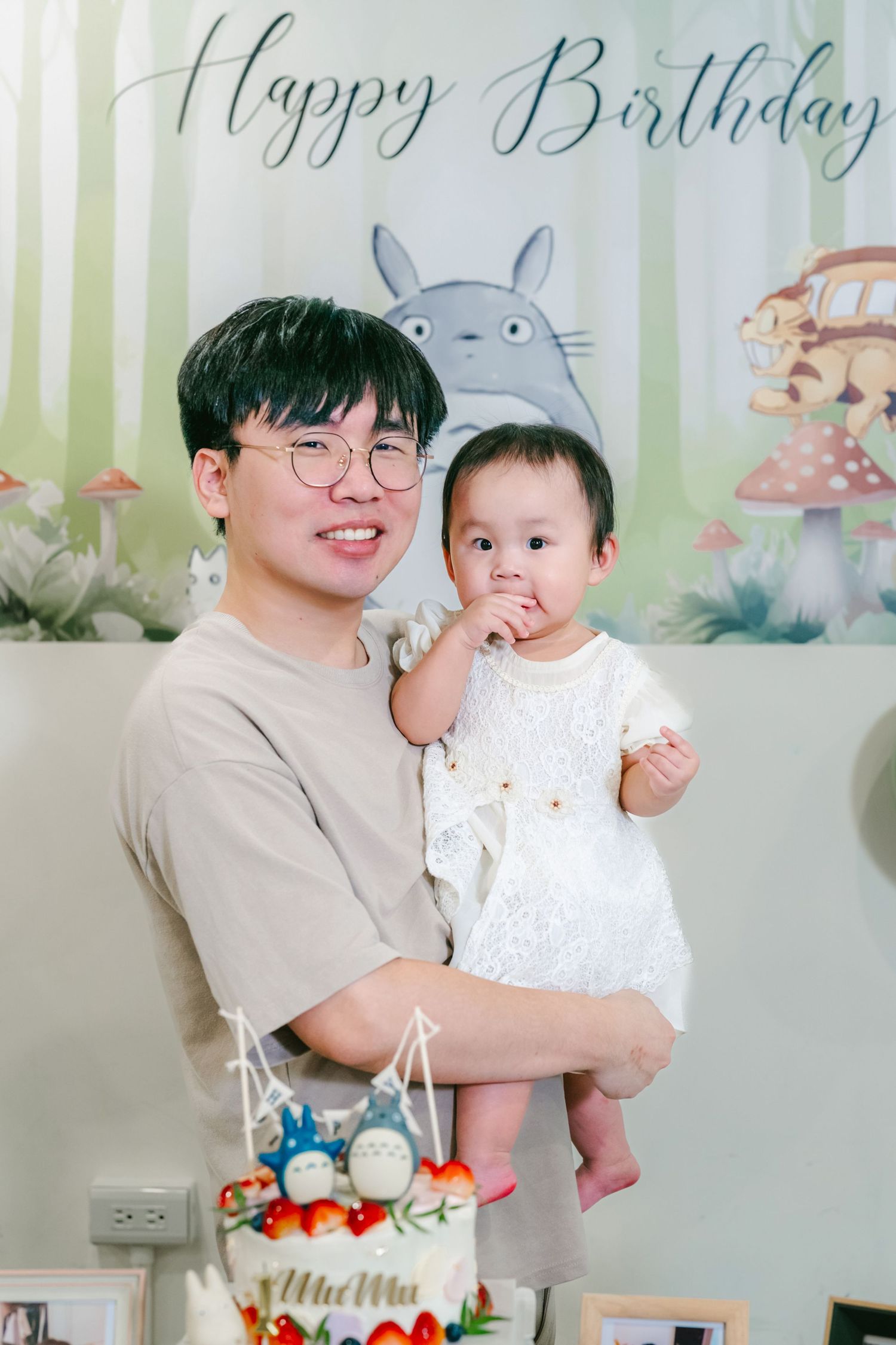 Birthday celebration scene with festive decorations, cake, and light green striped background.