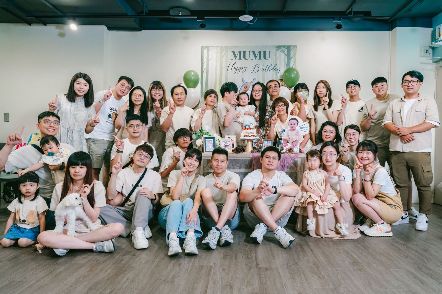 A large group of people in matching white and pink outfits gather together for a series of group photos.