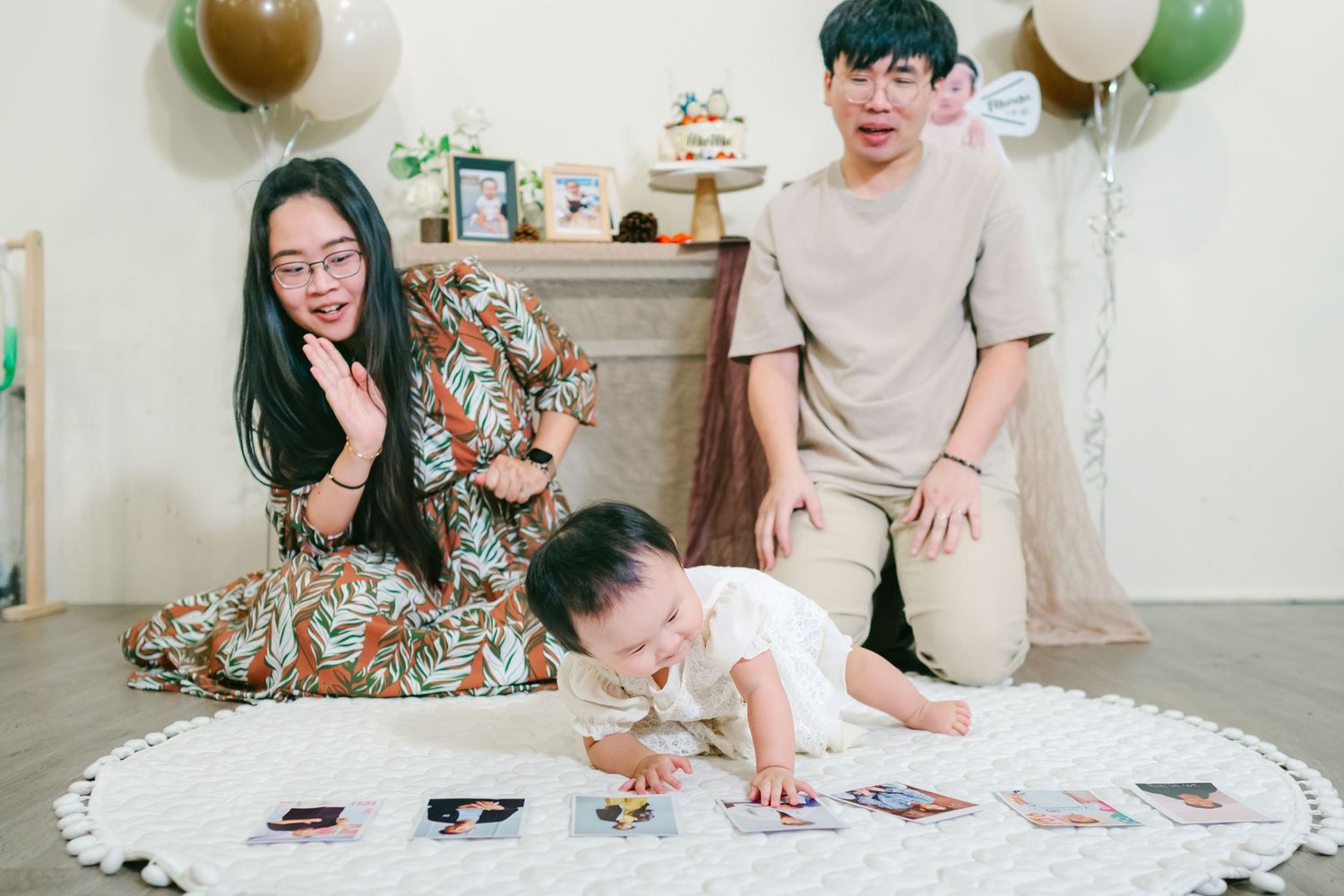 A couple relaxes on a couch while looking through photo prints laid out on a coffee table.