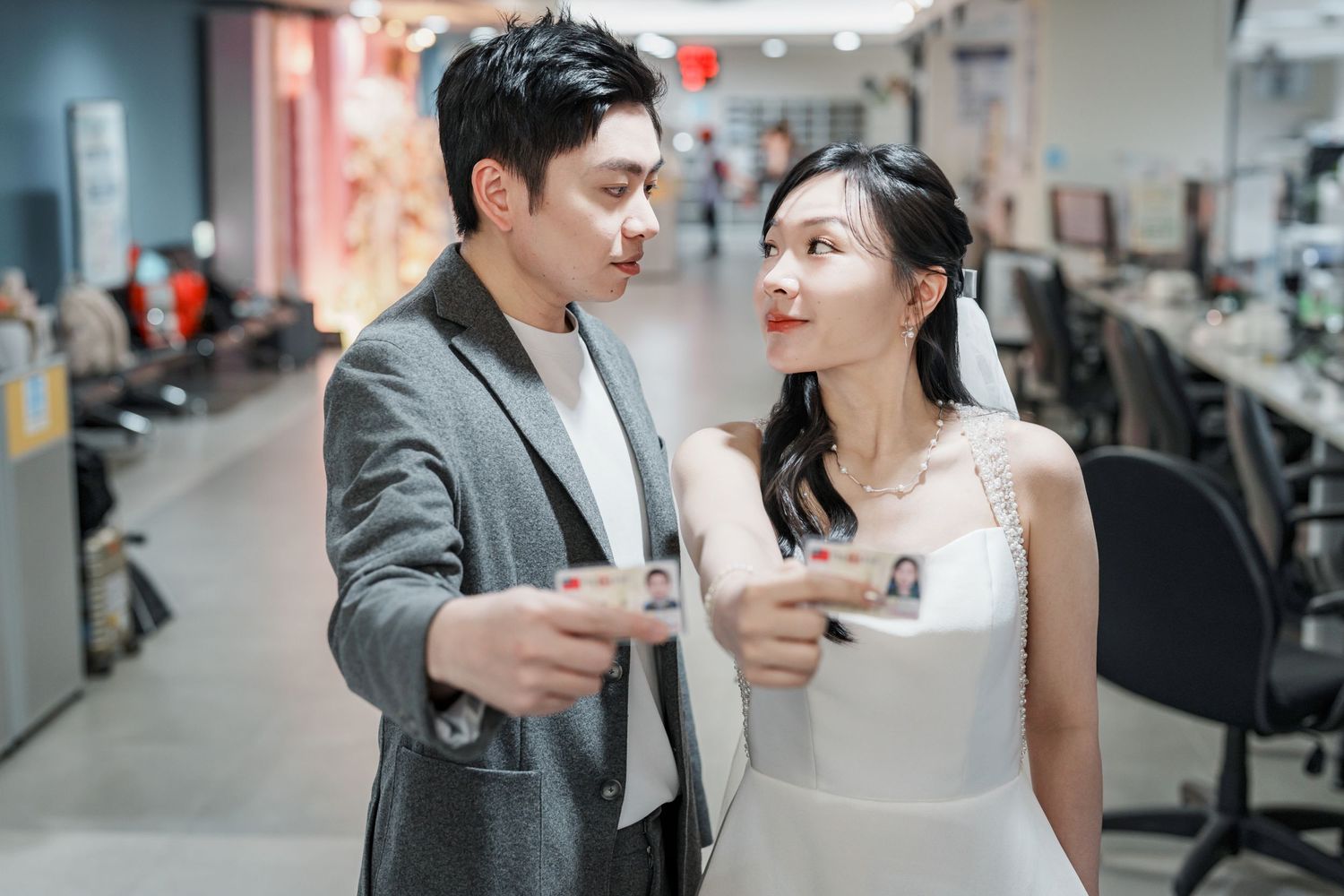 A couple in formal attire shares coffee and conversation at a modern office workspace.