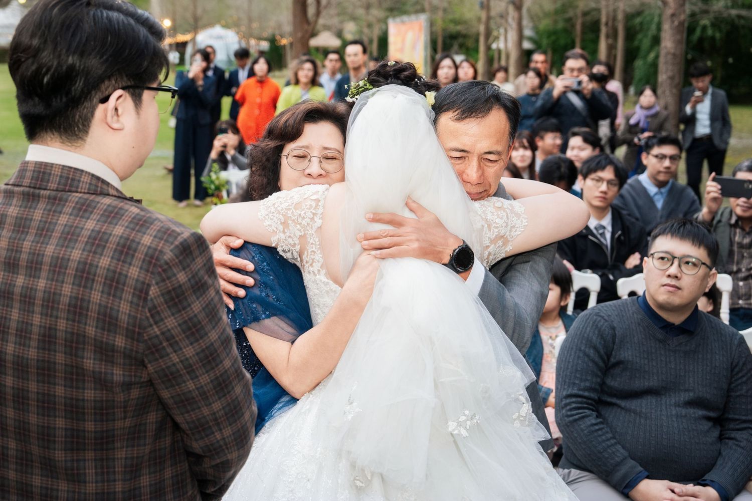 A group of wedding guests gather outdoors for a celebratory moment during a traditional ceremony.