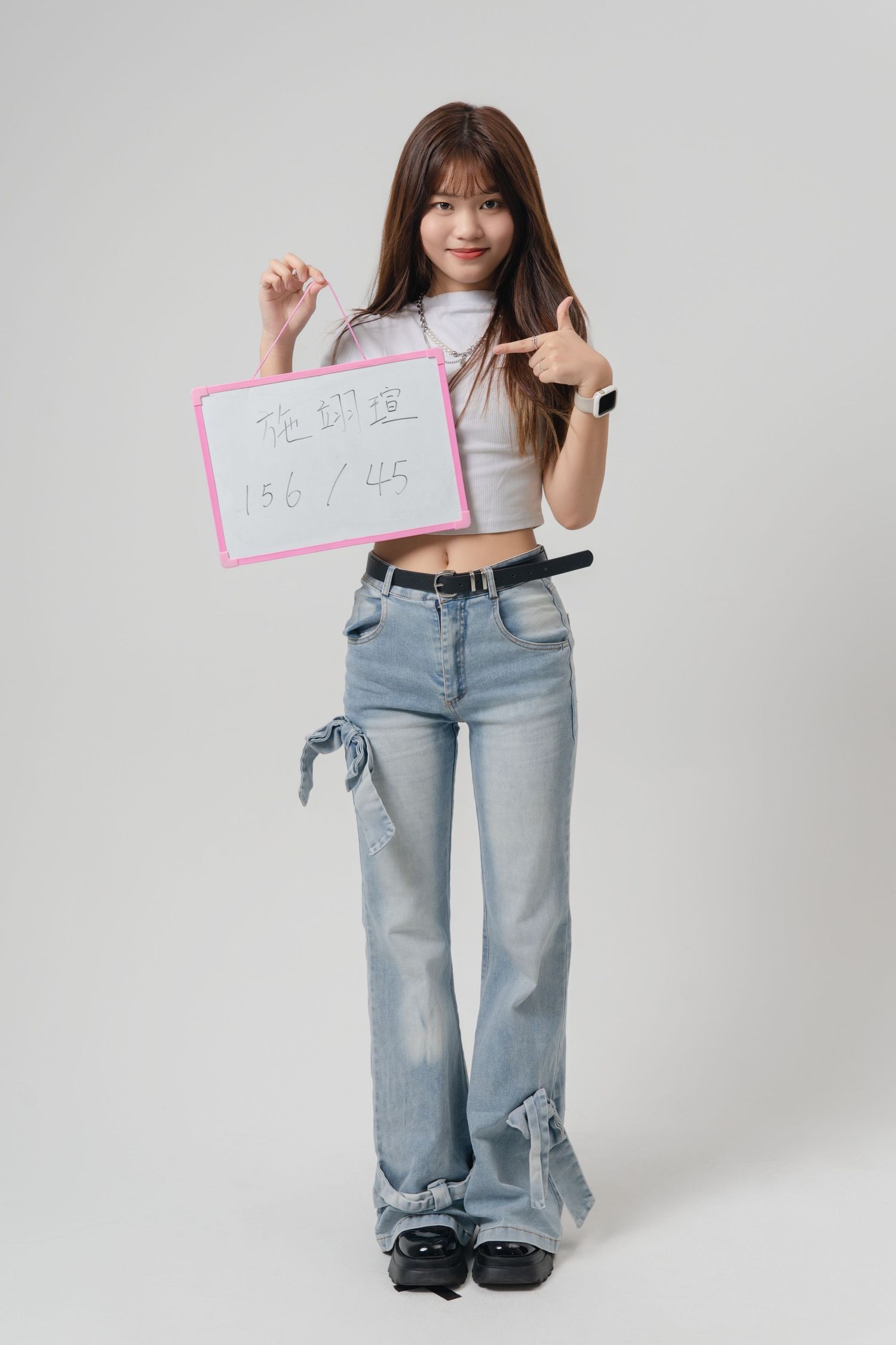 A series of four fashion photos showing someone wearing light wash baggy jeans and a white top against a white backdrop.