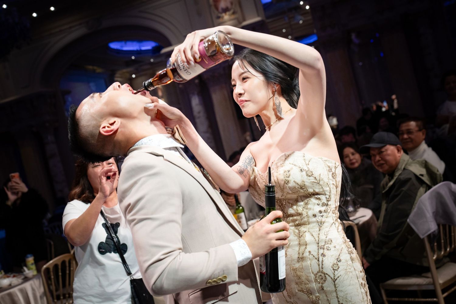 A couple shares a romantic dance together during their wedding celebration on a dimly lit dance floor.