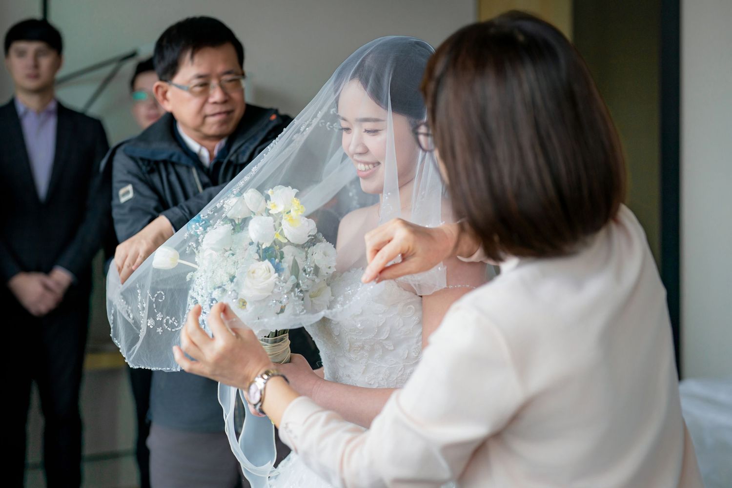 A wedding celebration with guests toasting and sharing drinks at an elegant indoor reception.