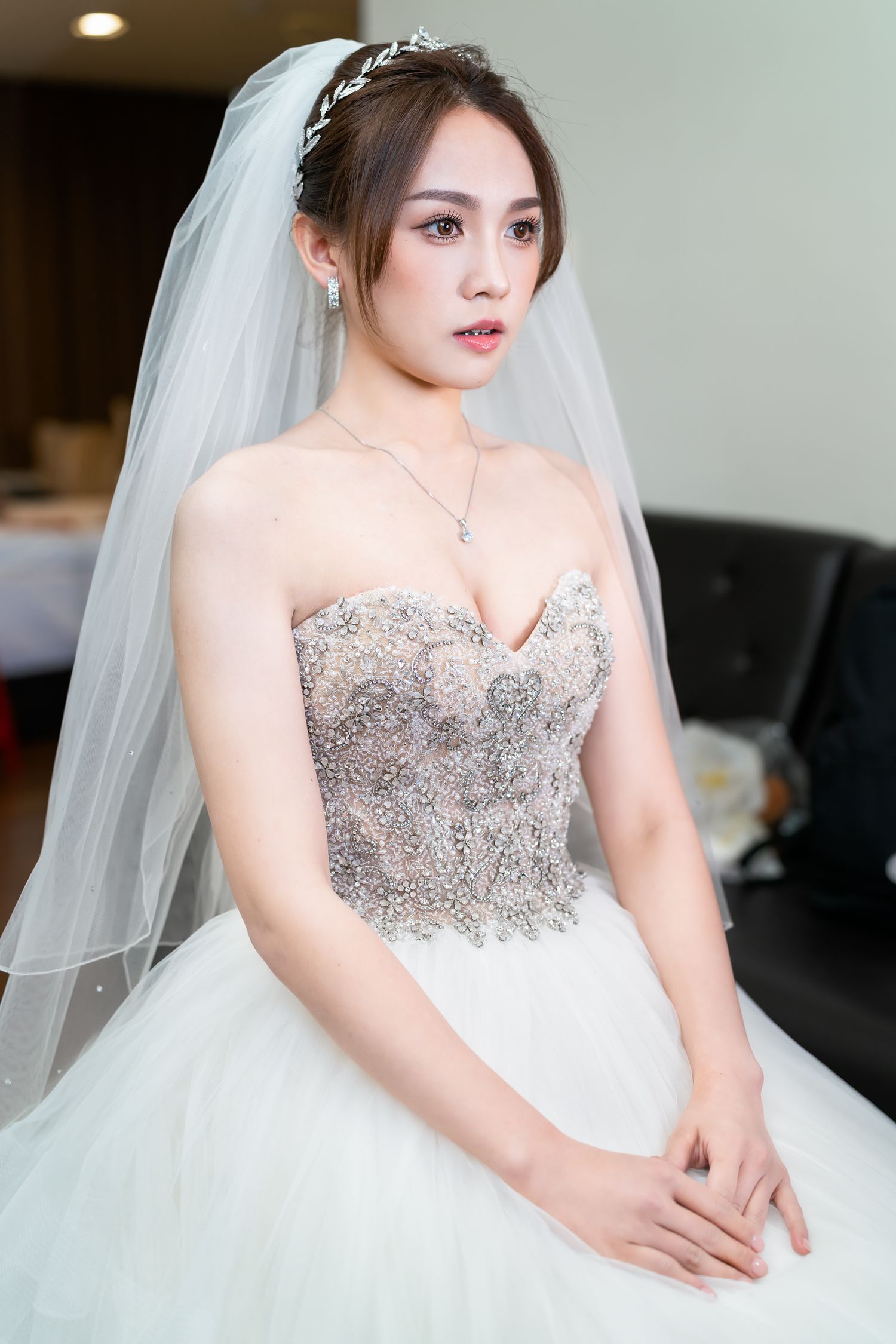 Elegant bridal portrait featuring intricate beaded bodice and flowing tulle veil.