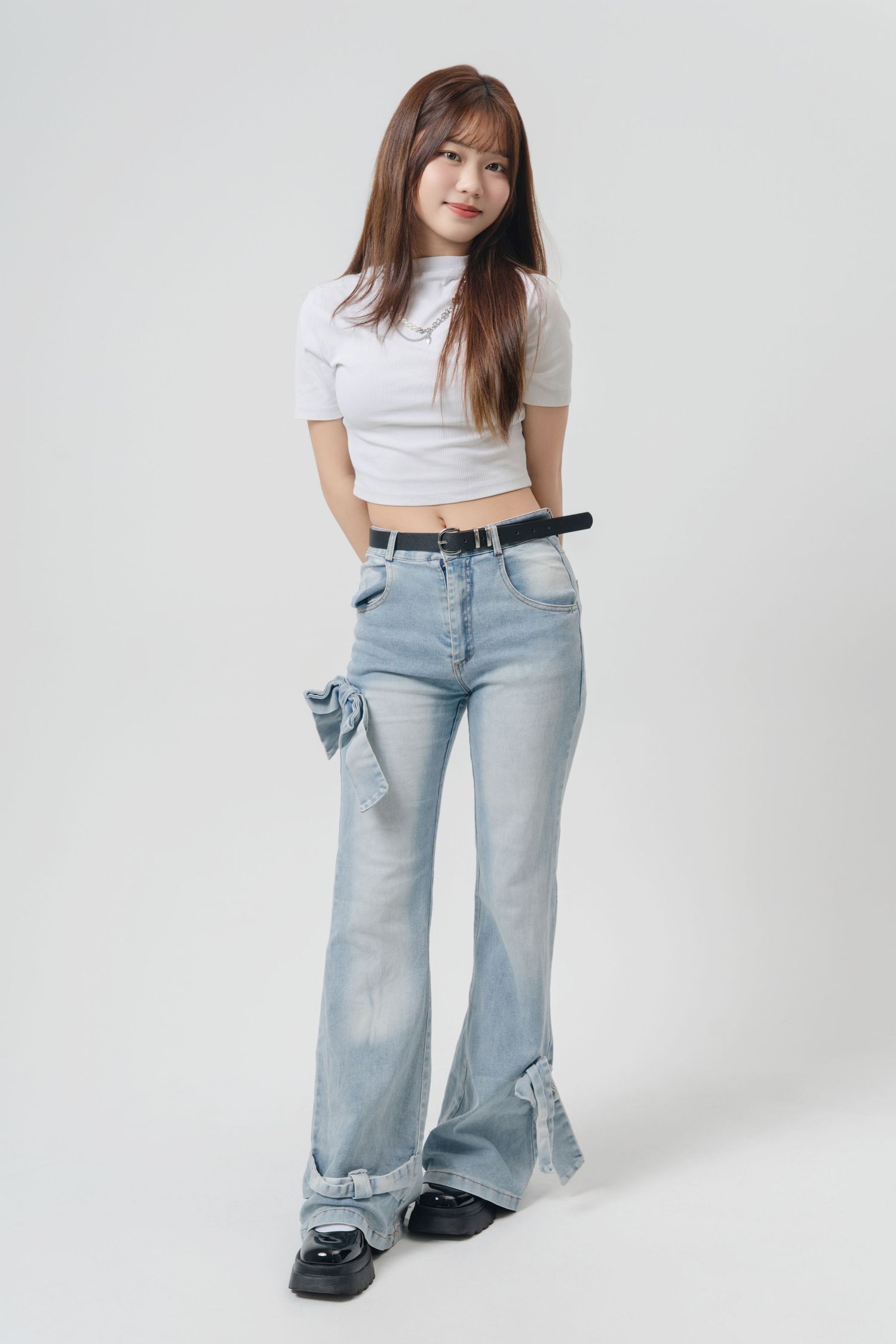 Three fashion photos showing a casual outfit with light wash wide-leg jeans paired with a white crop top and black shoes.