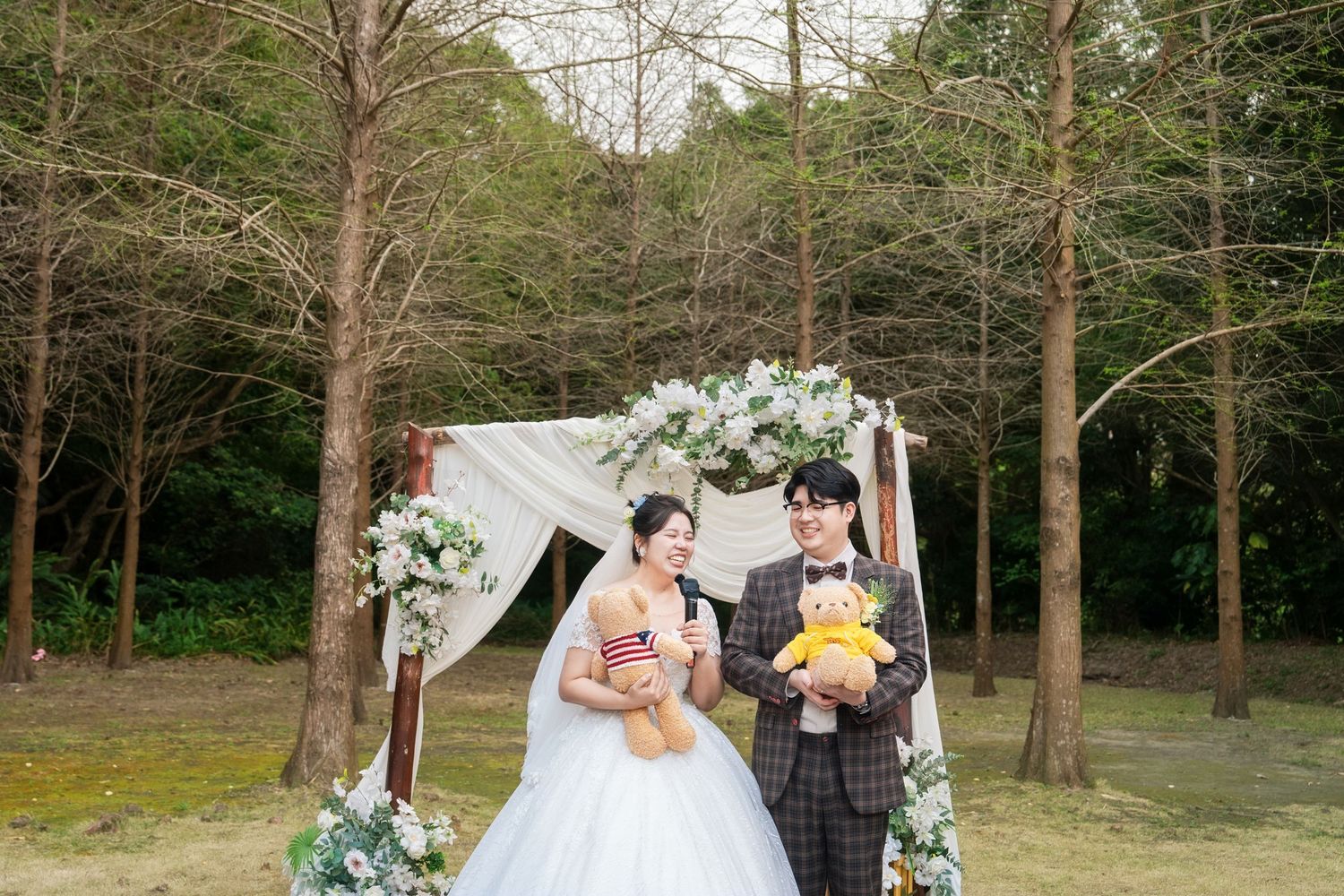 Wedding party poses in a wooded outdoor setting during a springtime celebration.