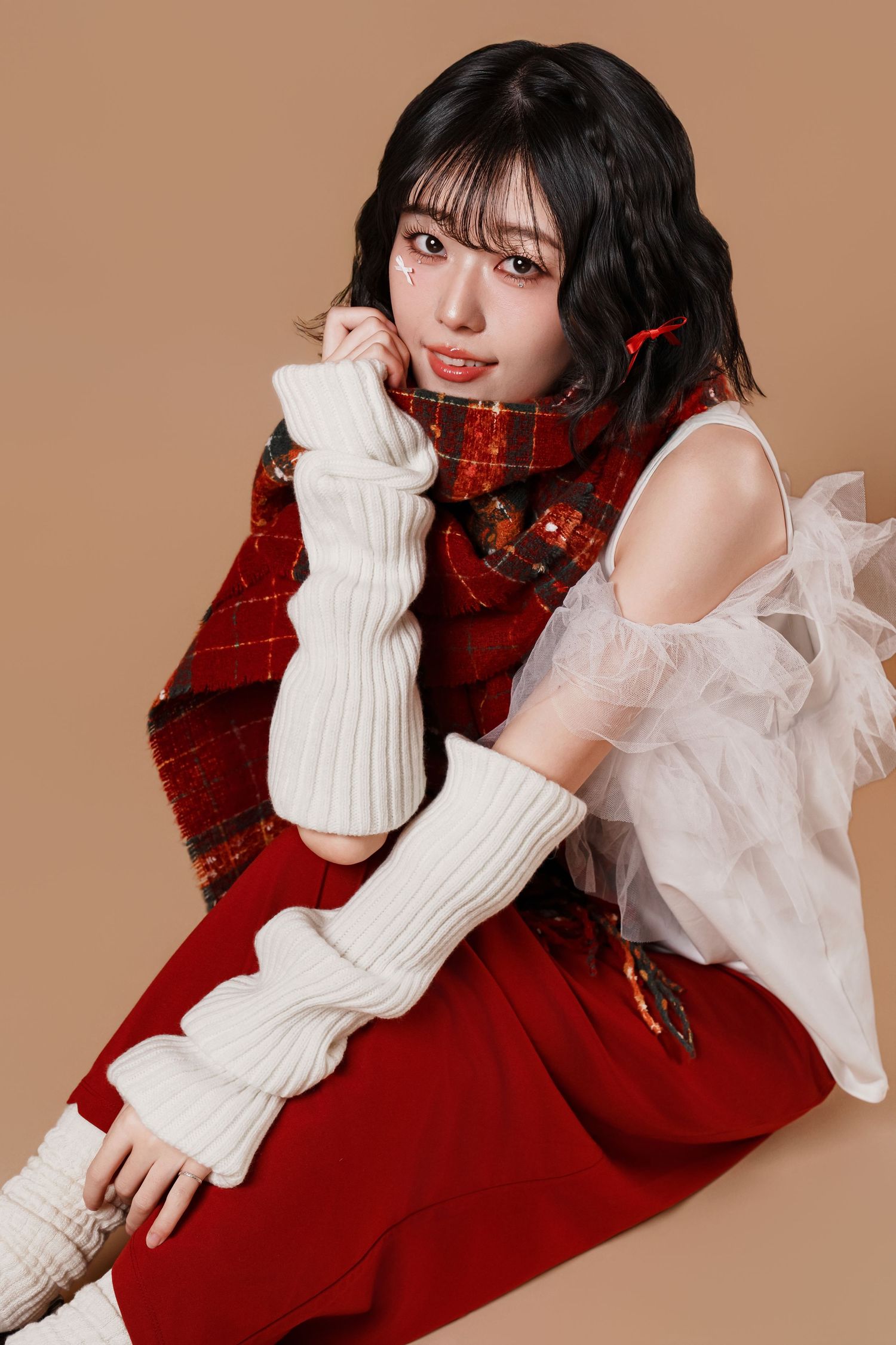 A person wearing a red dress and white knit gloves poses in a series of elegant fashion shots against a beige background.