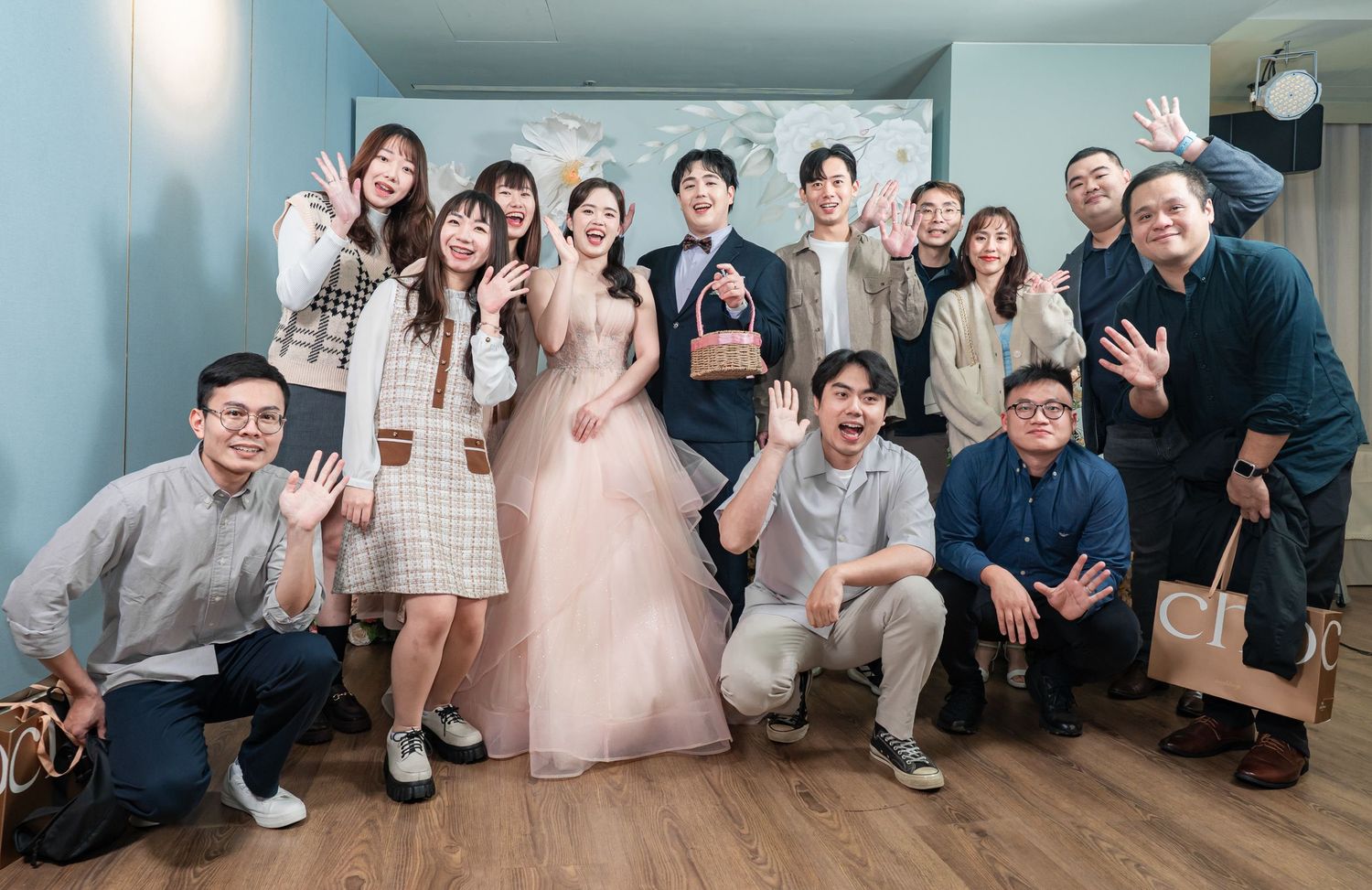 A panoramic collage of wedding party members posing together on a wooden floor in a bright indoor setting.