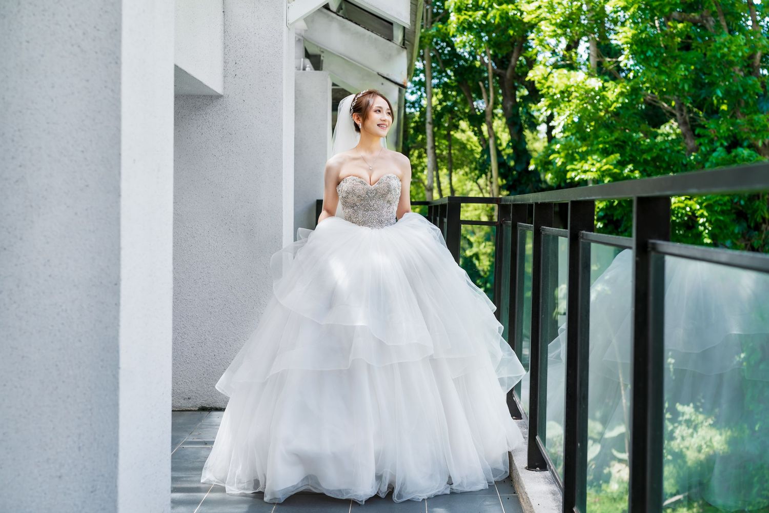 A princess-style wedding dress with layered tulle skirt photographed on an outdoor terrace.