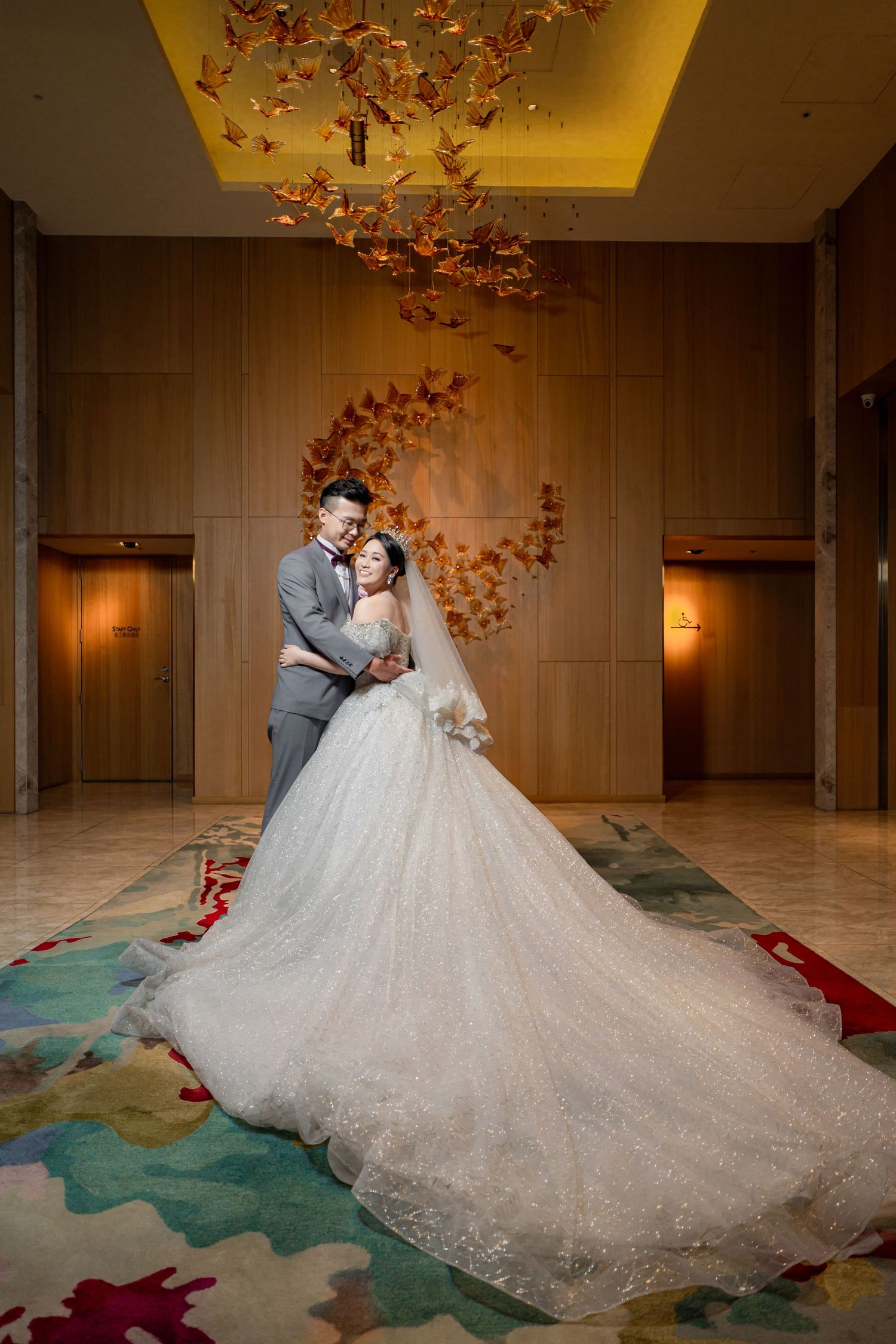 Romantic wedding couple shares intimate moments in an elegant venue decorated with cascading autumn leaves and dramatic lighting.