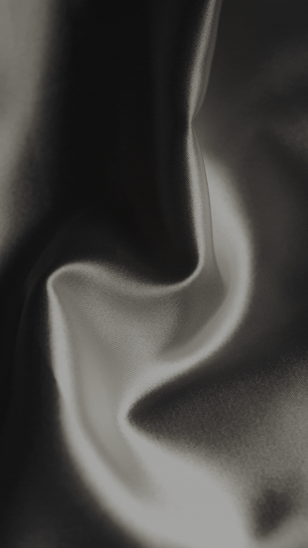 Abstract black and white photograph showing smooth curving lines and gradients creating a flowing smoke-like pattern.