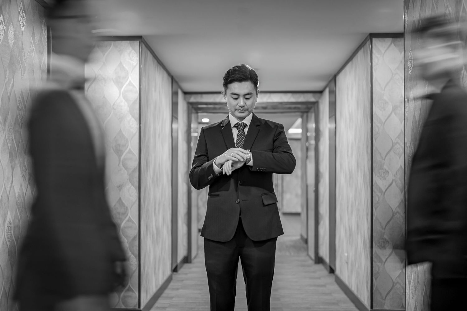 Artistic black and white hallway photos showing a person in formal attire creating multiple reflective poses.
