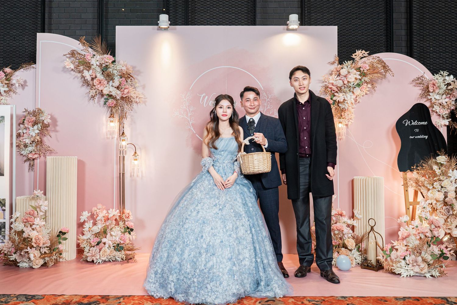 A wedding celebration with floral decor and a light blue ballgown in a romantic pink-lit venue.